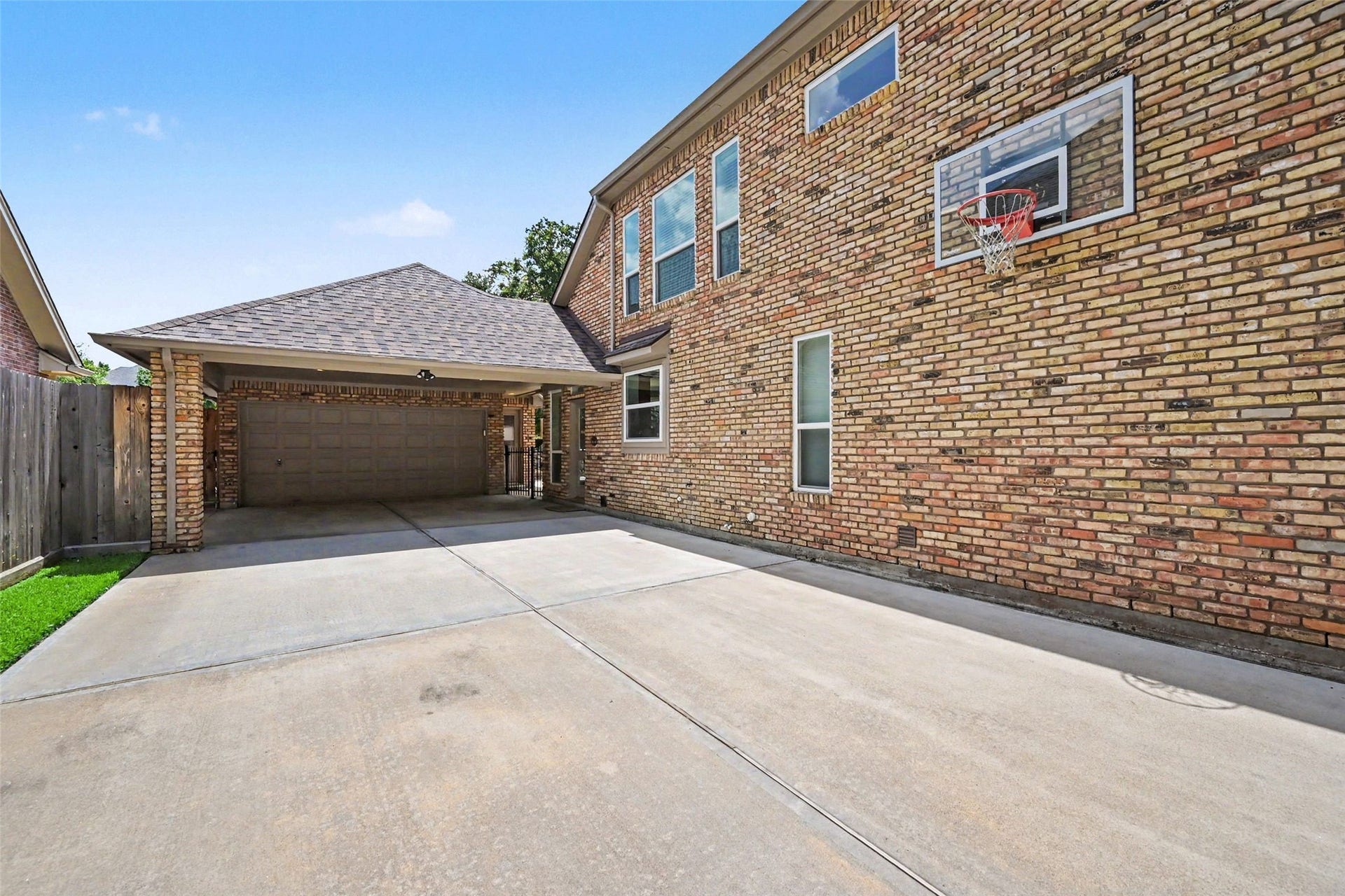 2907 Winding Shore Lane, Katy, TX 77450 Elegant brick home with a charming arched entryway, situated on a lush corner lot with mature trees, ample driveway space, and a welcoming walkway.