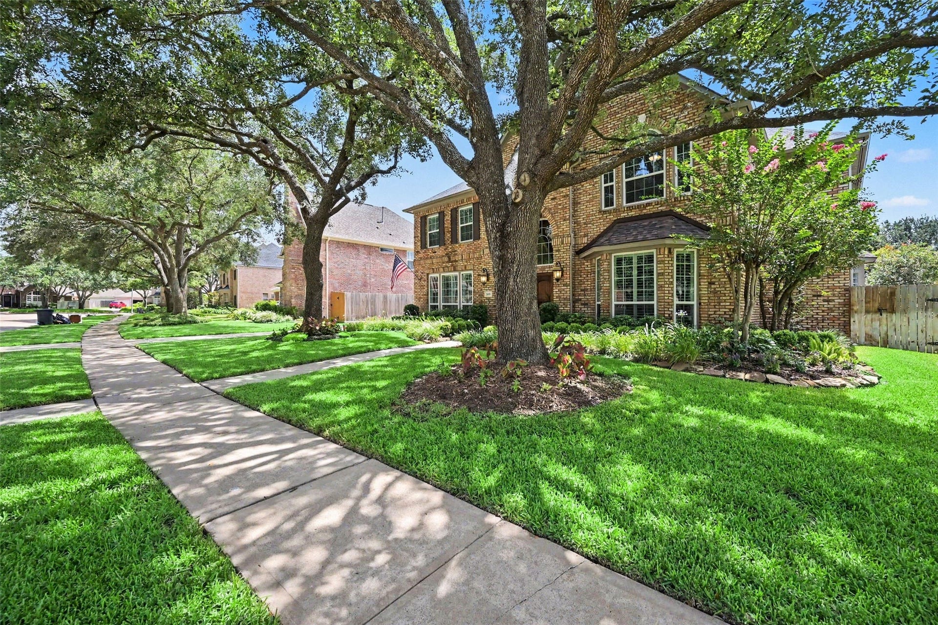 2907 Winding Shore Lane, Katy, TX 77450 Beautiful brick home surrounded by lush landscaping and mature trees, creating a warm and inviting first impression. The well-maintained front yard and timeless curb appeal are nestled within a peaceful, established neighborhood.