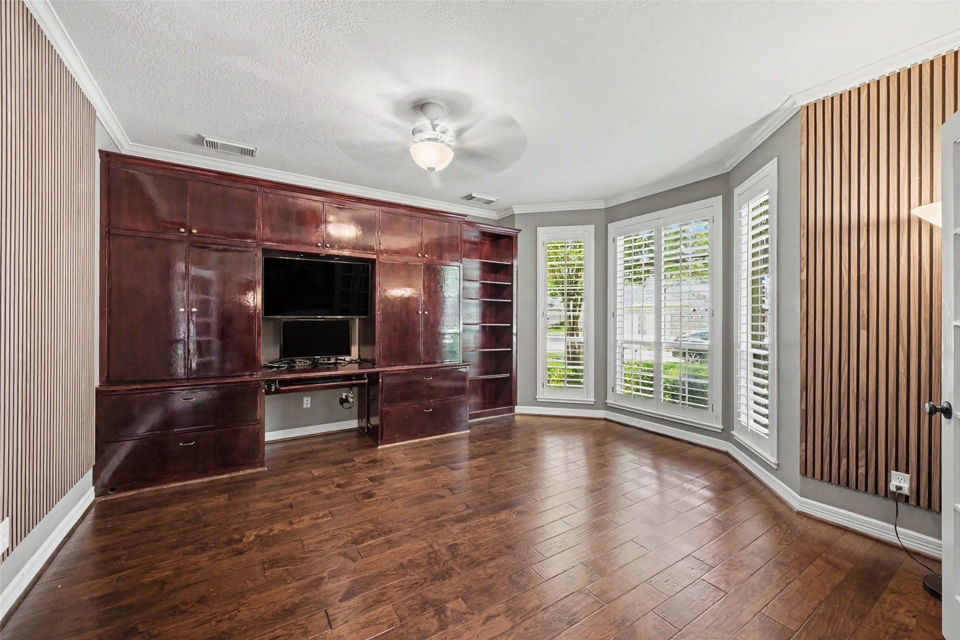 2907 Winding Shore Lane, Katy, TX 77450 Spacious private home office featuring elegant plantation shutters, a full wall of custom built-in cabinetry, abundant storage, and ample workspaceideal for working from home while keeping everything organized.