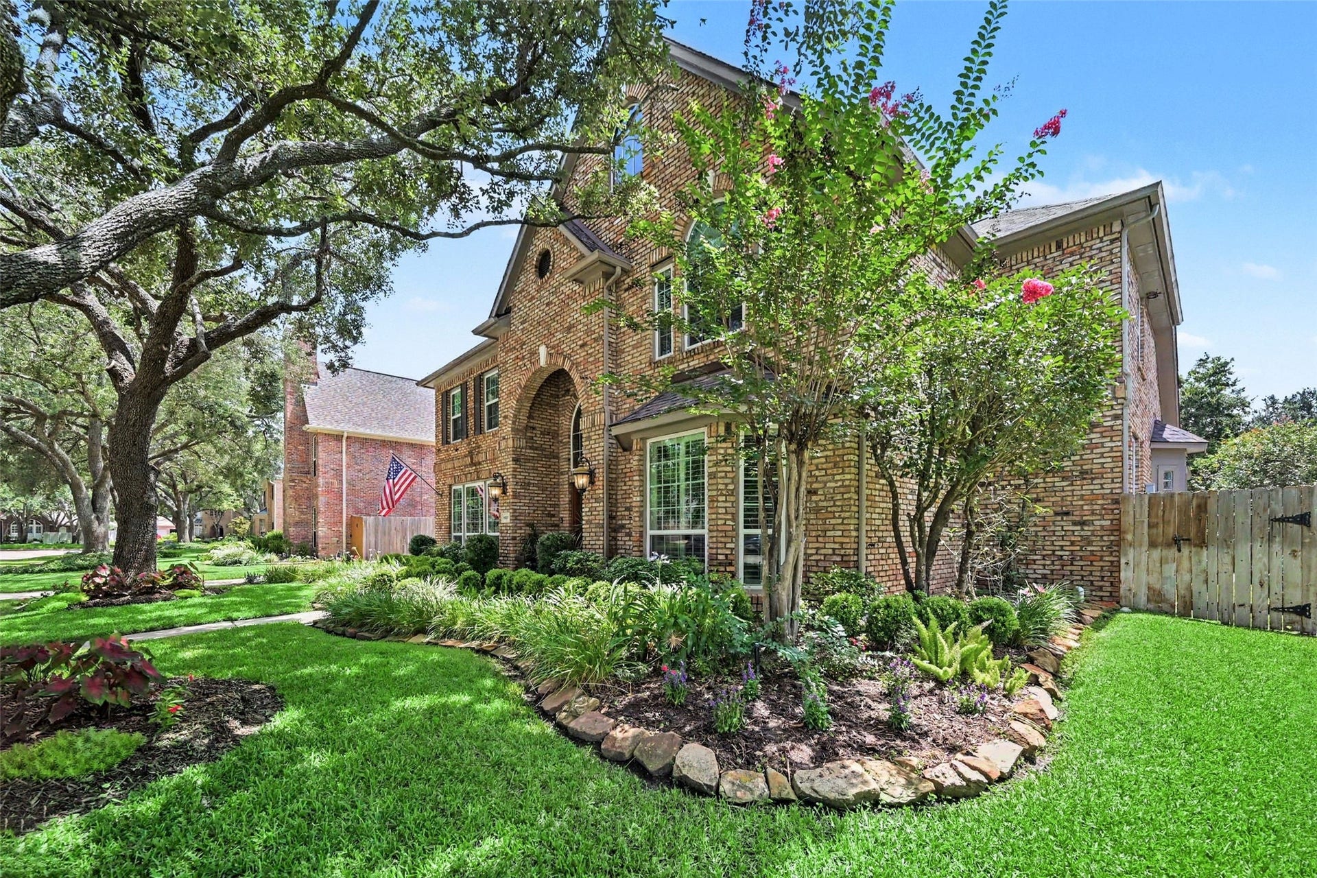 2907 Winding Shore Lane, Katy, TX 77450 Charming brick entryway featuring a classic wooden door, elegant arched window, and beautifully landscaped greenery for a welcoming ambiance.