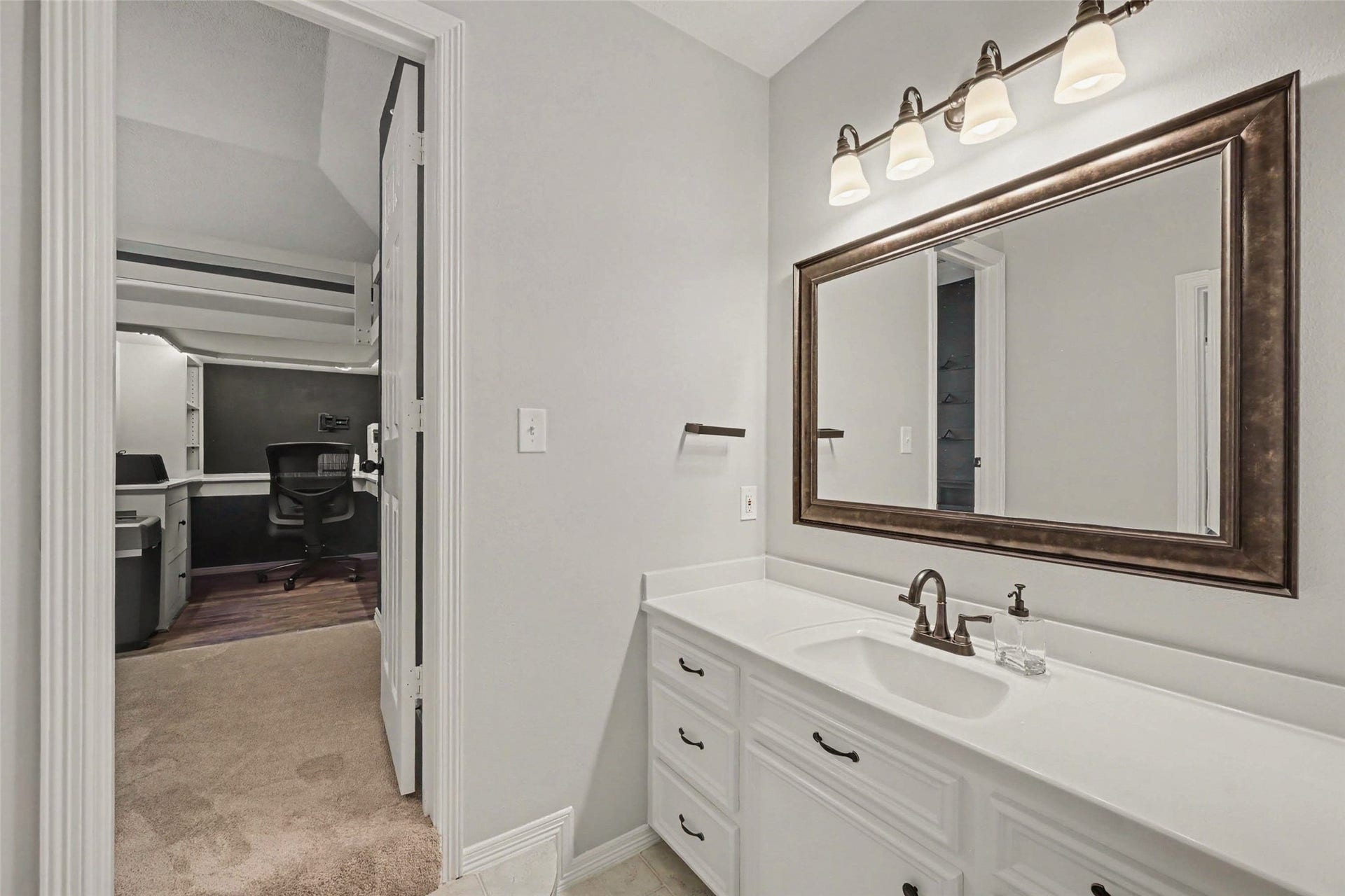 2907 Winding Shore Lane, Katy, TX 77450 Elegant bathroom with a large mirror, modern lighting, and a spacious vanity.