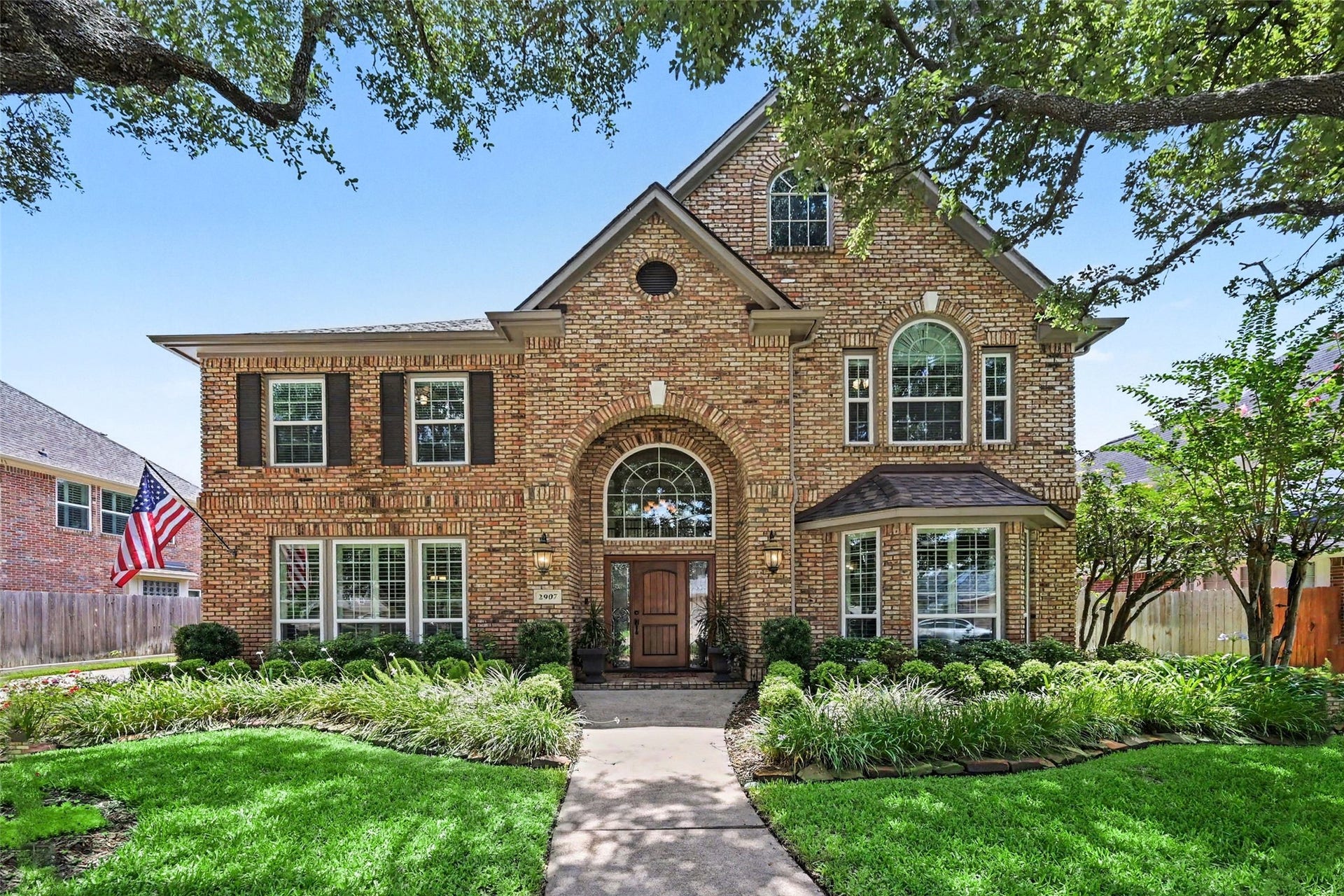 2907 Winding Shore Lane, Katy, TX 77450 Beautiful two-story brick home featuring charming arched windows, an inviting front entrance, and timeless architectural details. Surrounded by lush landscaping and mature trees, this home offers exceptional curb appeal in the prestigious gated section of Cinco Ranch, creating a peaceful and welcoming setting.