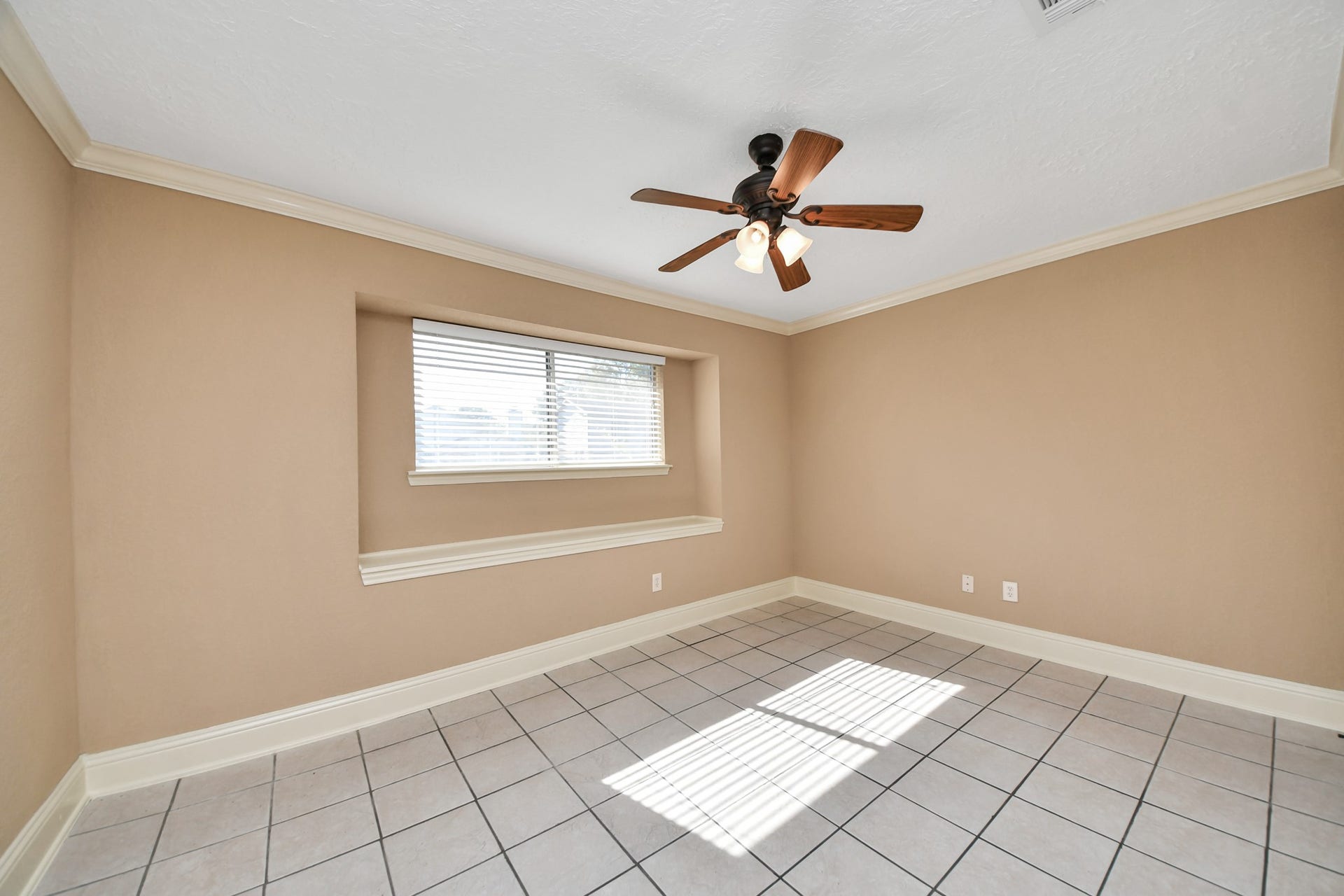 935 Grand Junction Drive, Katy, TX 77450 This inviting first-level secondary bedroom offers an abundance of natural light through a charming recessed window, creating a bright and welcoming atmosphere.