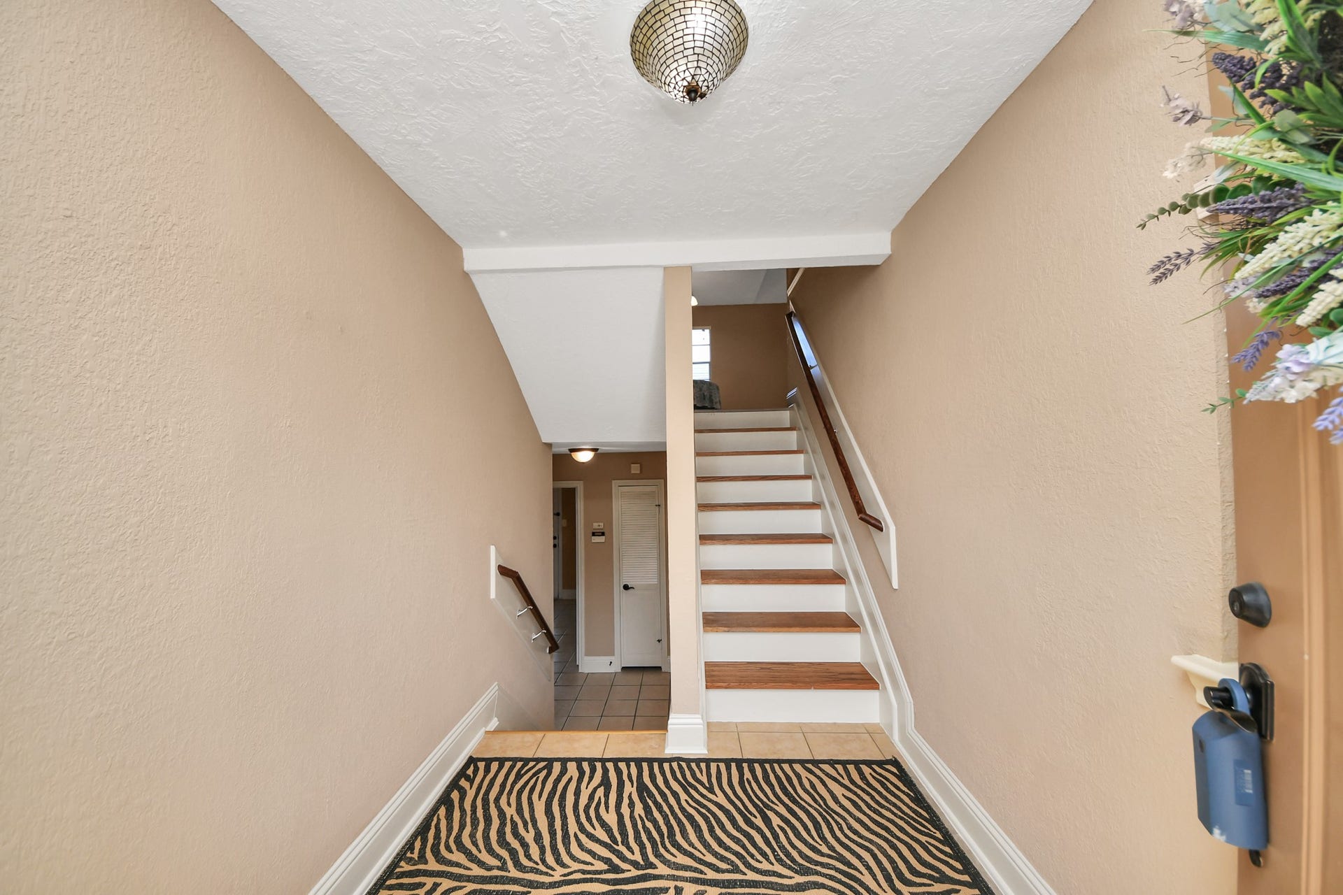 935 Grand Junction Drive, Katy, TX 77450 From the moment you enter, the distinctive split-level design introduces an appealing separation of living spaces. Wood-look stair treads, contrasting white risers, and traditional handrails create architectural interest, while the entryway provides access to both the upper and lower levels. This thoughtful configuration offers flexibility and a sense of separation between the home's gathering areas and additional rooms.