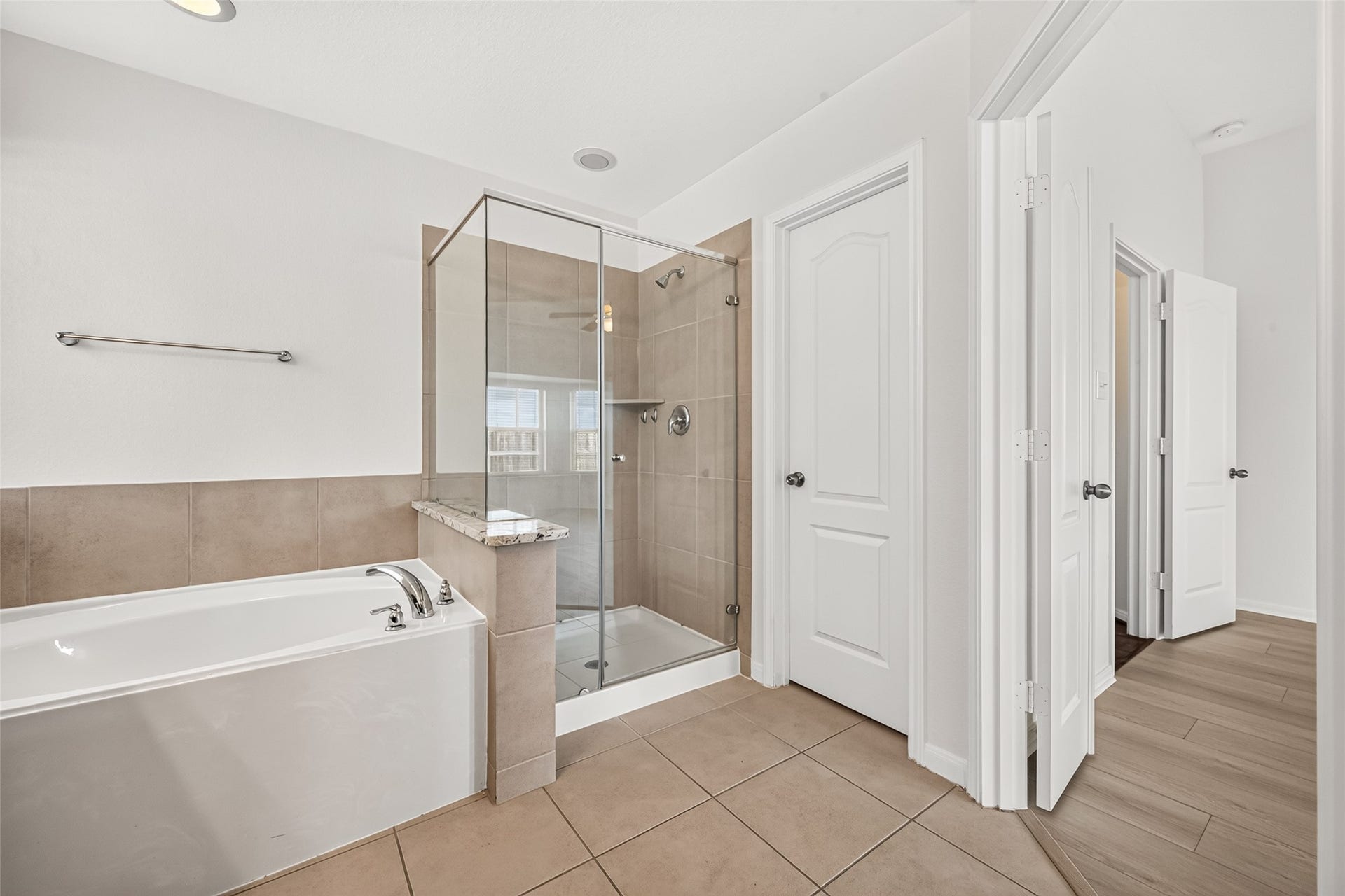 Primary bathroom with double sinks, soaking tub, and separate shower