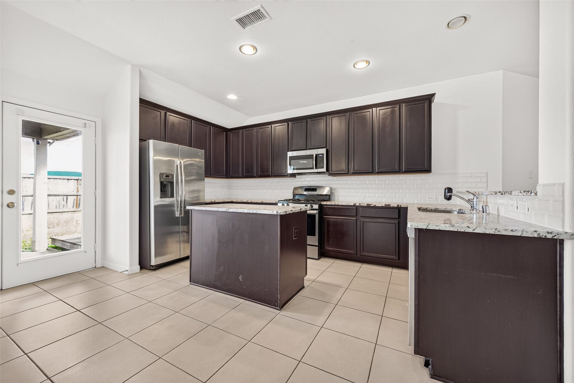 So much counter and cabinet space in this kitchen with direct access to the covered back patio