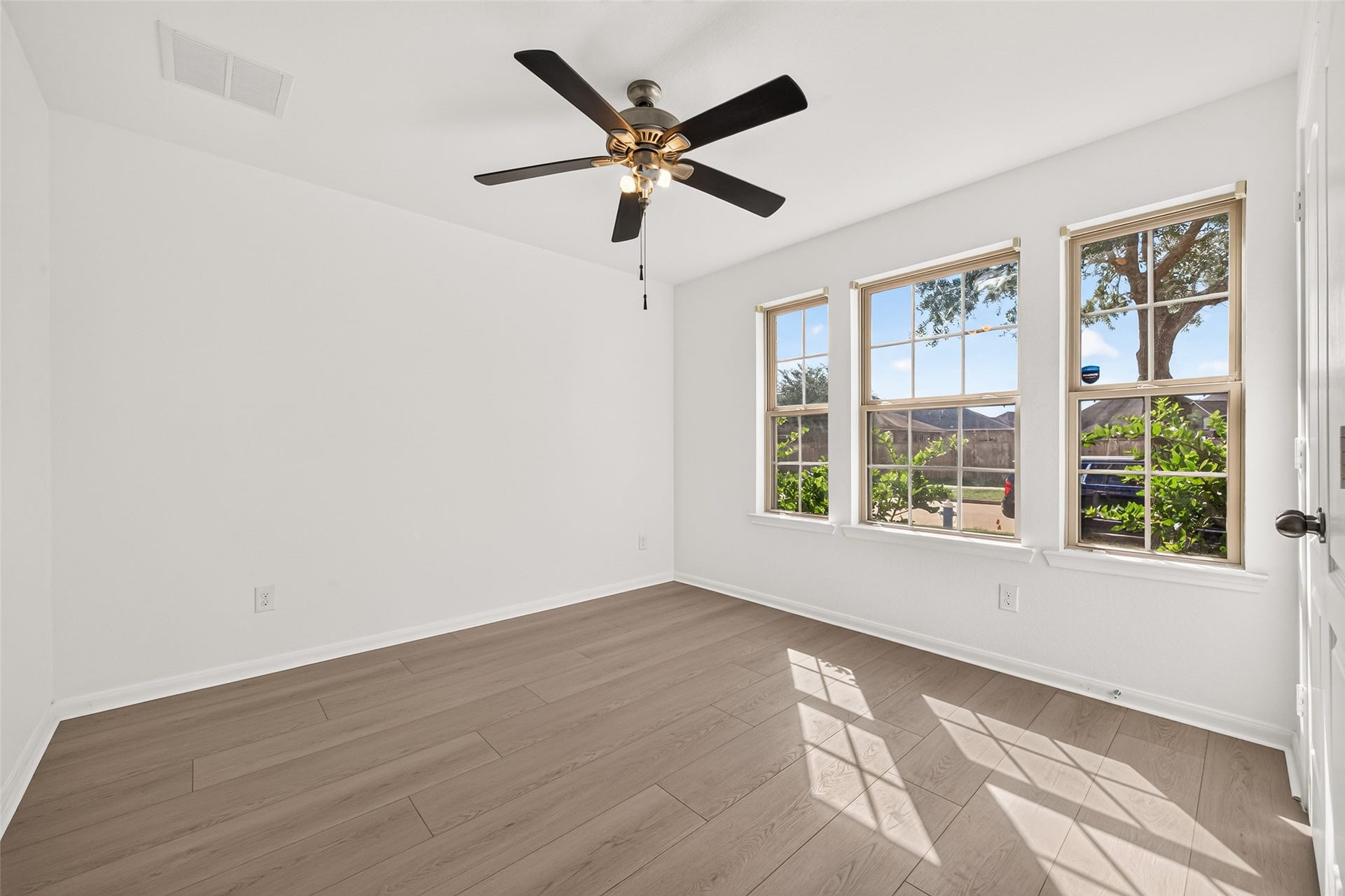 Secondary bedroom 1 with new flooring and fresh paint overlooks the front yard.  Blinds are being replaced.