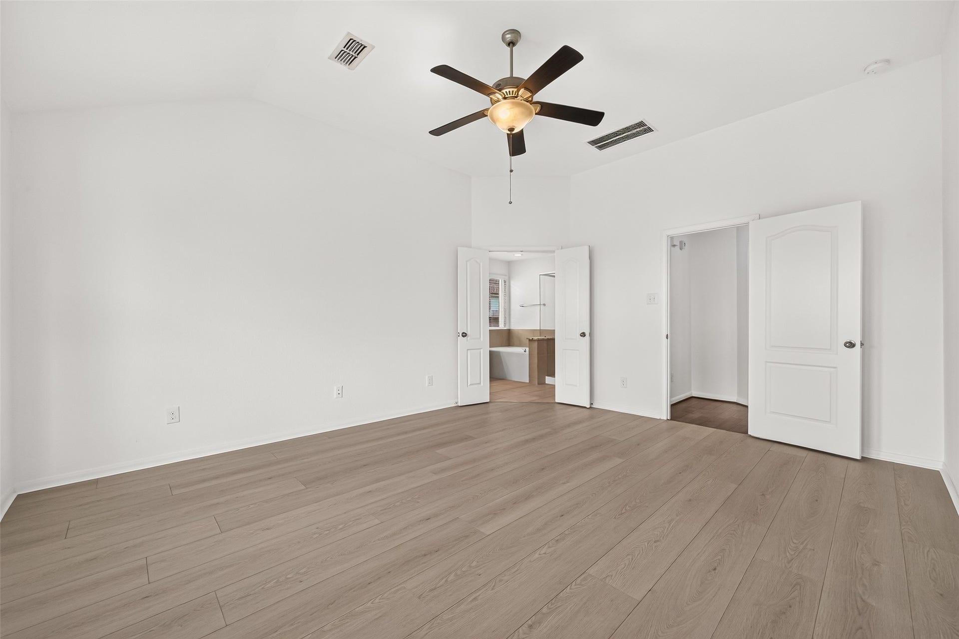 Primary bedroom has new wood look flooring and fresh paint. Features include the bay window and ceiling fan to keep cool during these Texas summers!