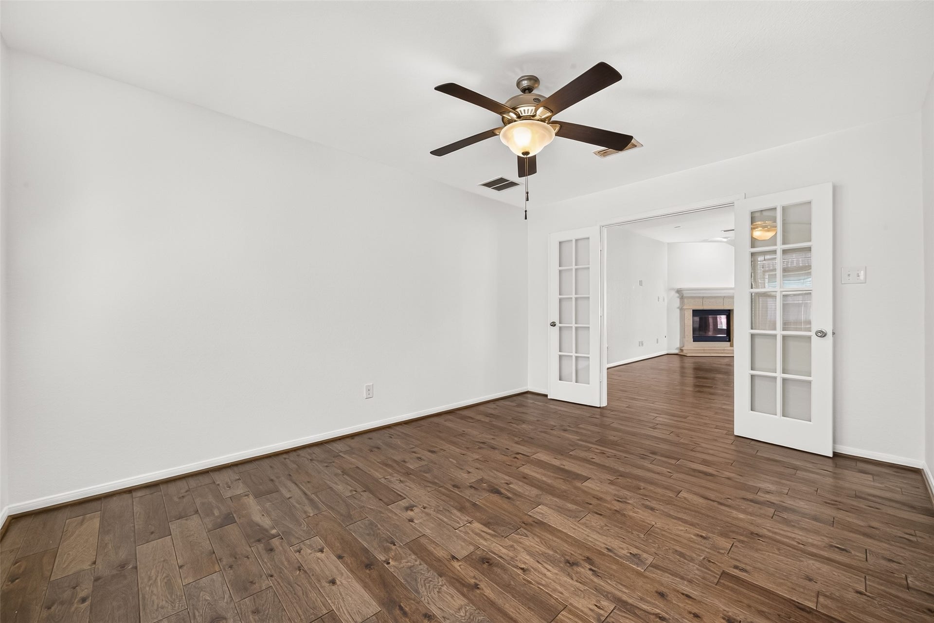 Spacious BONUS ROOM located off the living area can be used as a home office, gameroom, playroom, or fitness room. Features include wood look flooring, ceiling fan, and french doors for privacy.