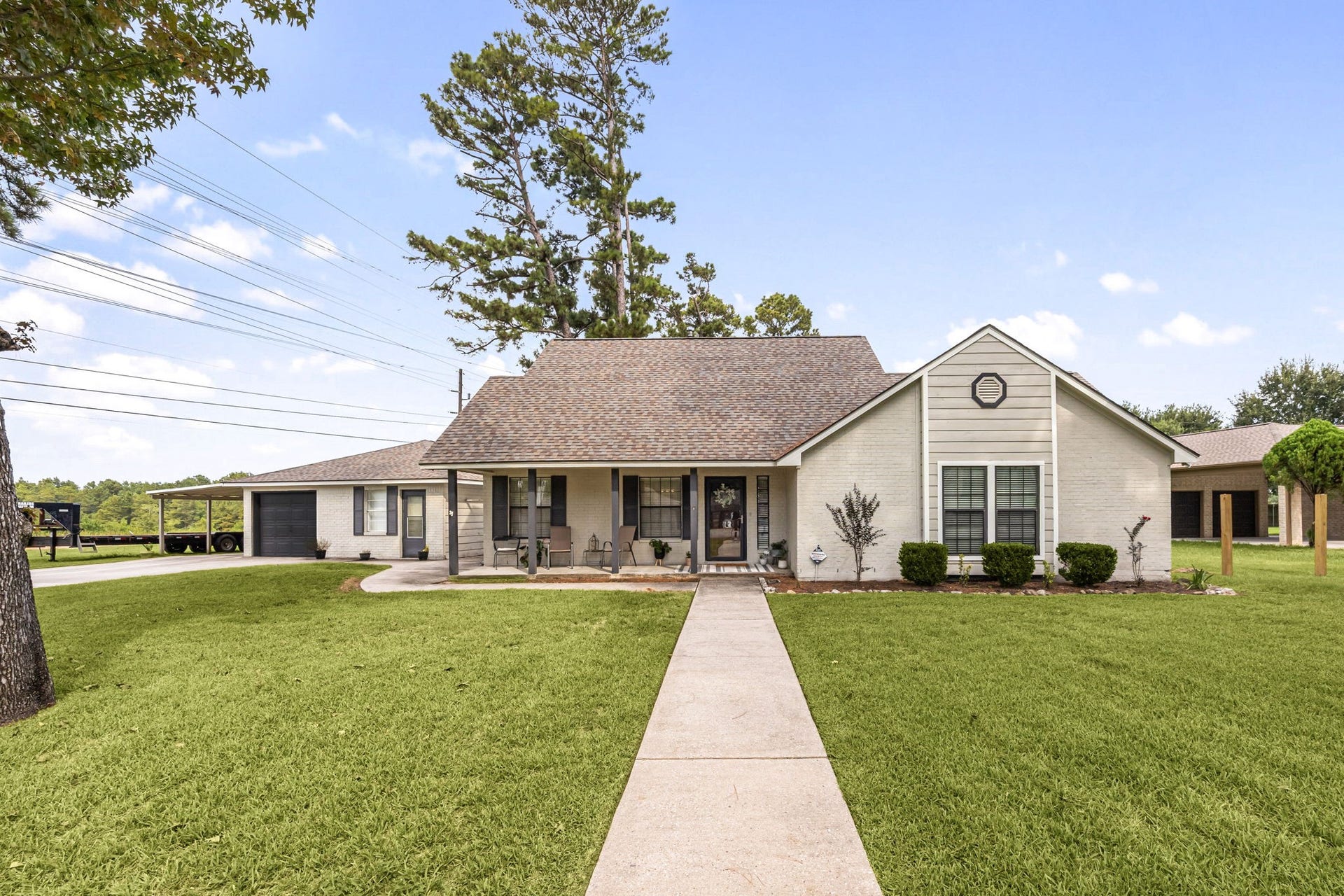 Welcoming front elevation with an expansive lawn and established landscaping.