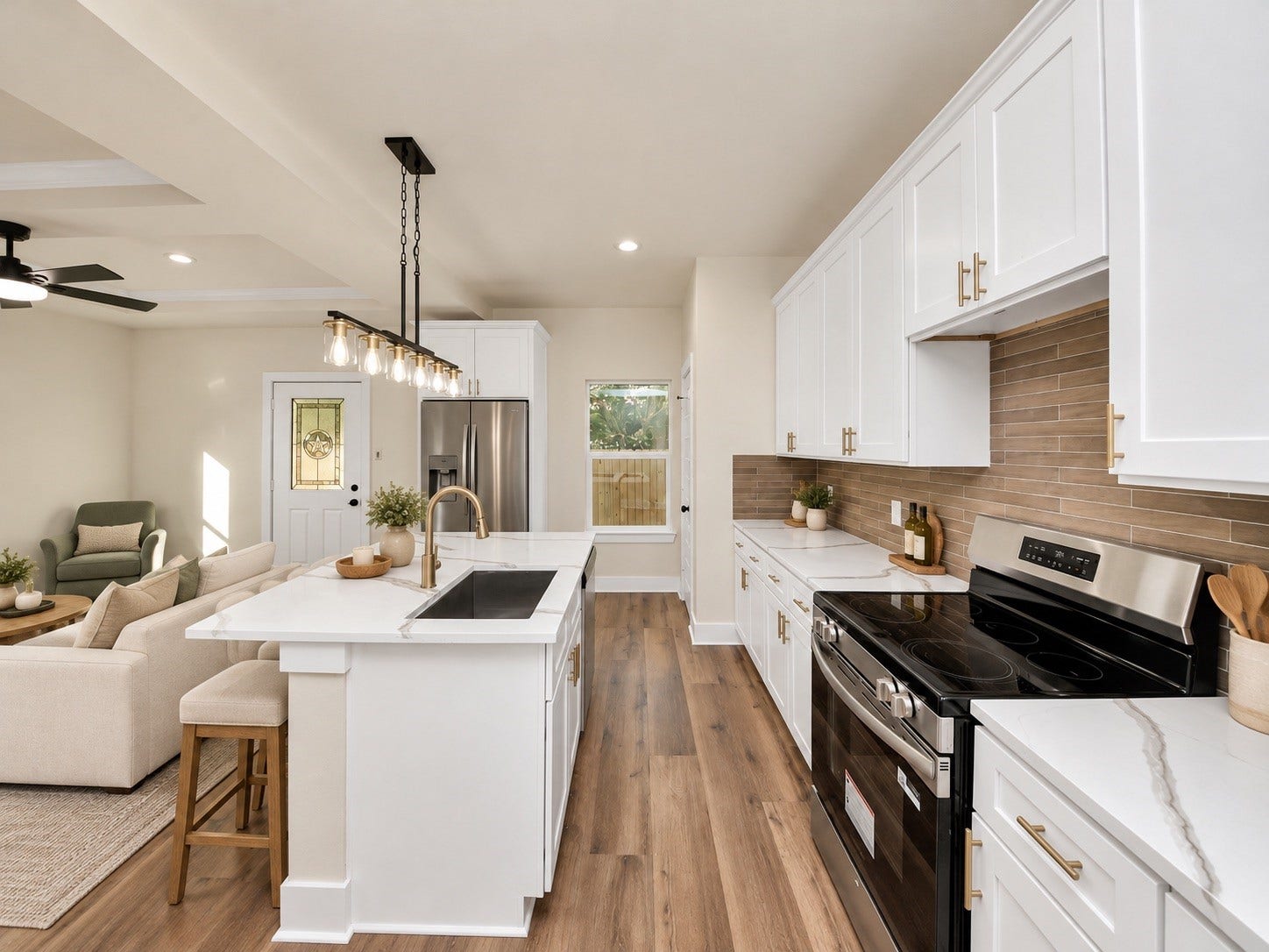 6675 Nielan Street, Houston, TX 77028 Spacious kitchen featuring a large center island with undermount sink, modern fixtures, soft-close cabinets & drawers, and an open layout overlooking the main living area | Virtually staged