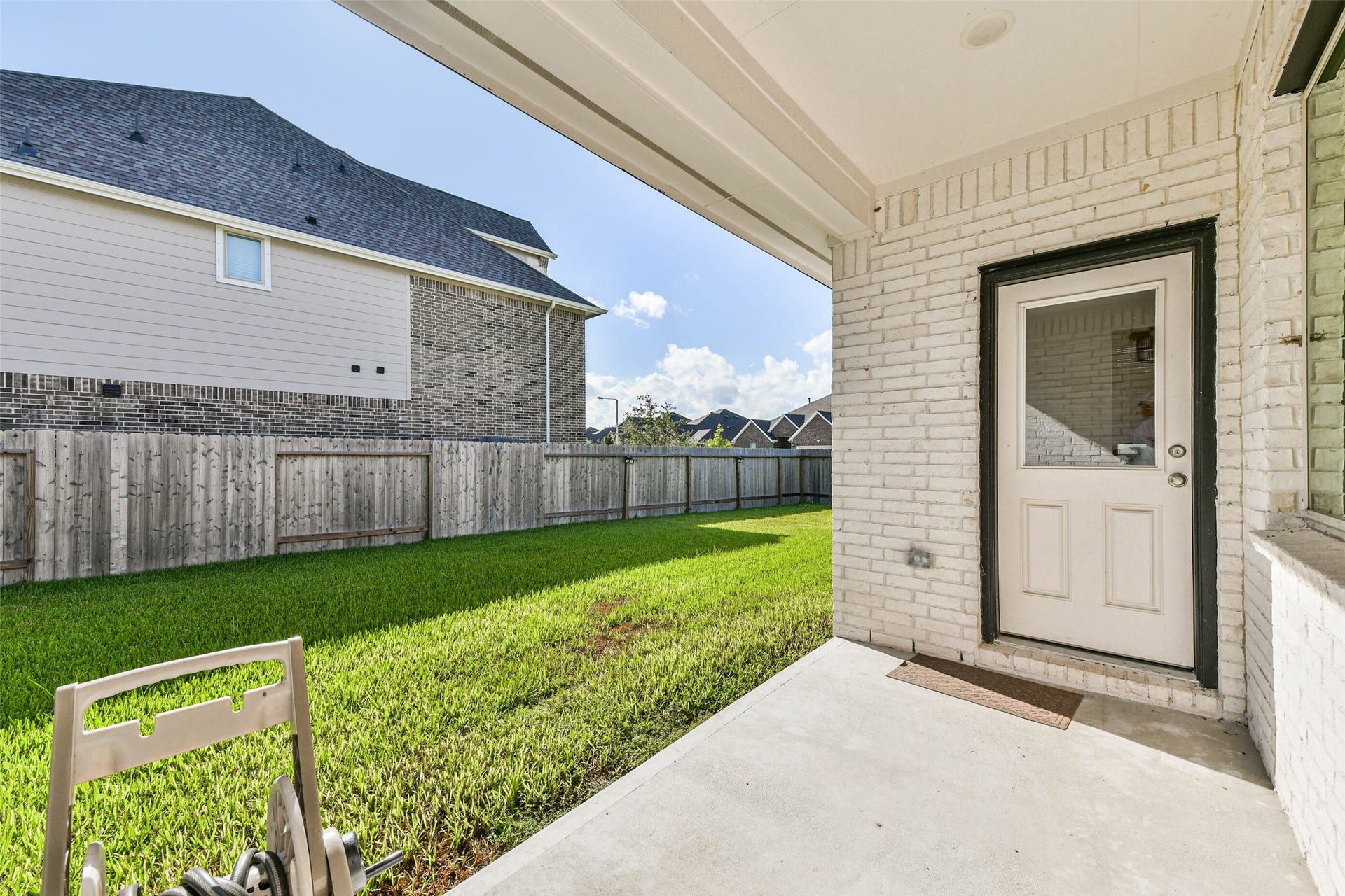 702 Campbell Drive, League City, TX 77573 Charming covered patio overlooking a lush, fenced backyard, perfect for outdoor relaxation and entertaining.