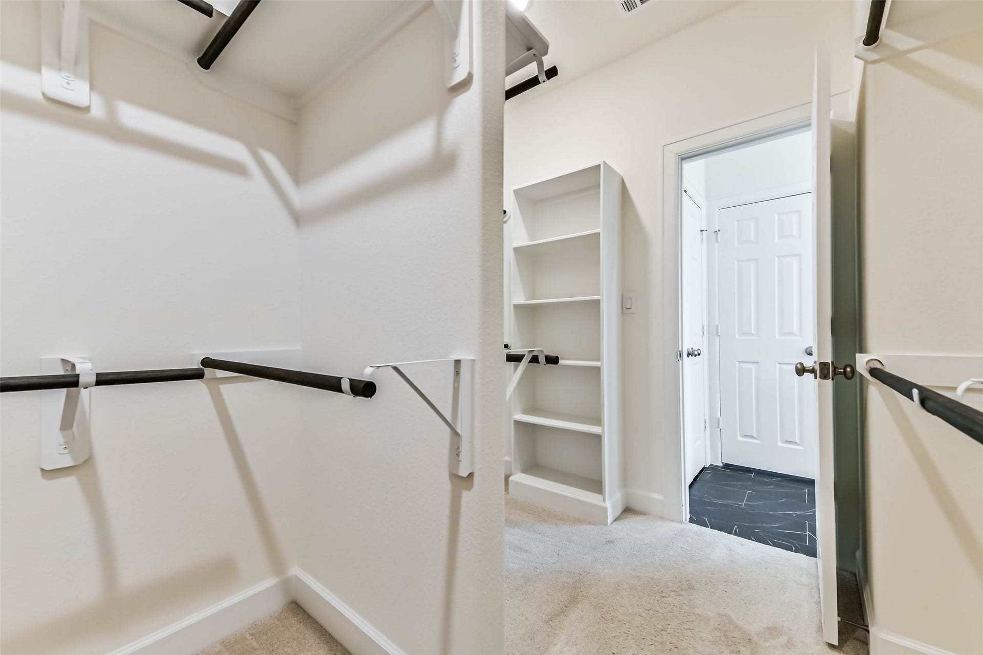 702 Campbell Drive, League City, TX 77573 Spacious walk-in closet with ample shelving and hanging space, leading to a tiled hallway.