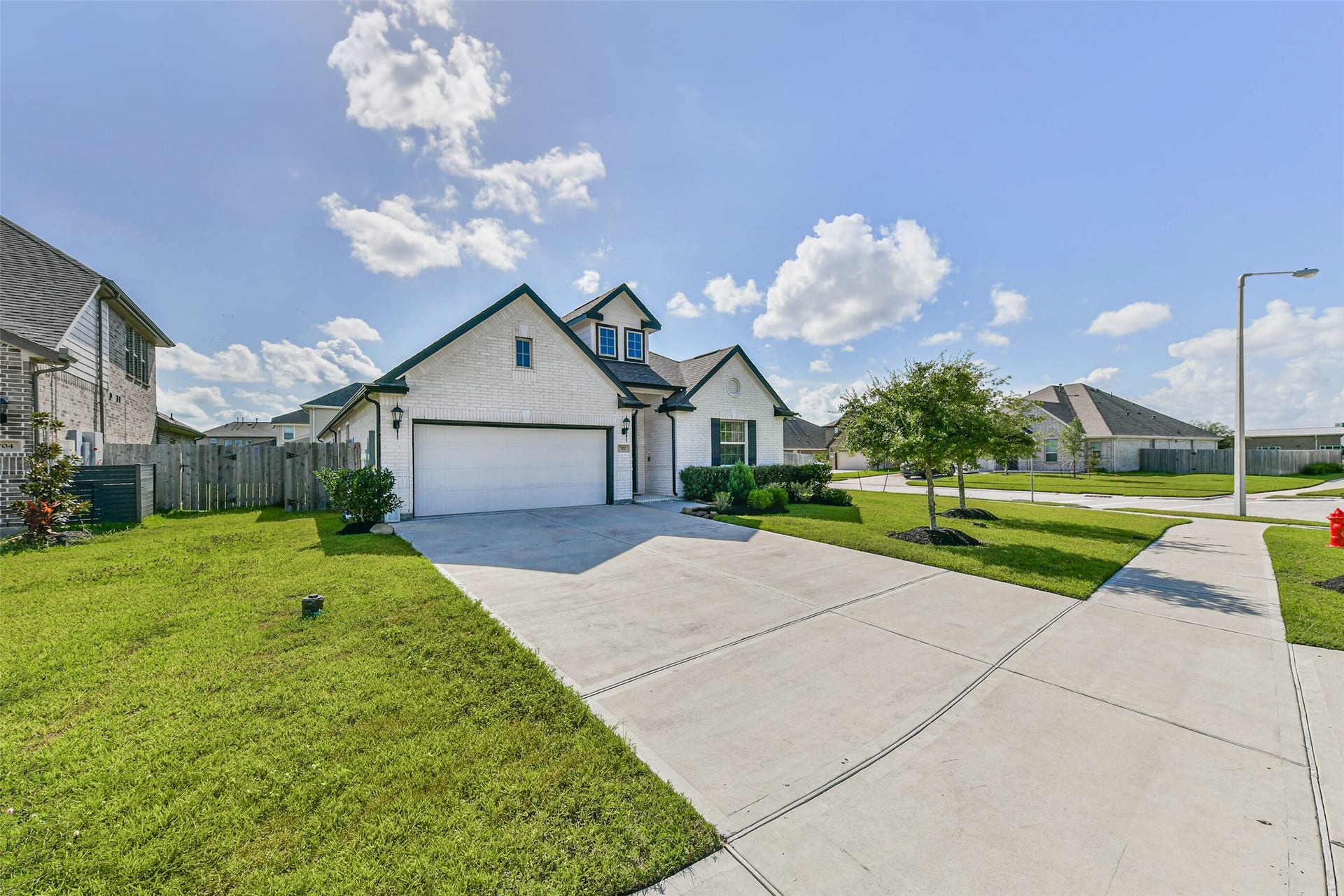 702 Campbell Drive, League City, TX 77573 Charming one-story home on a spacious corner lot, featuring a well-maintained lawn and an inviting driveway leading to a two-car garage.