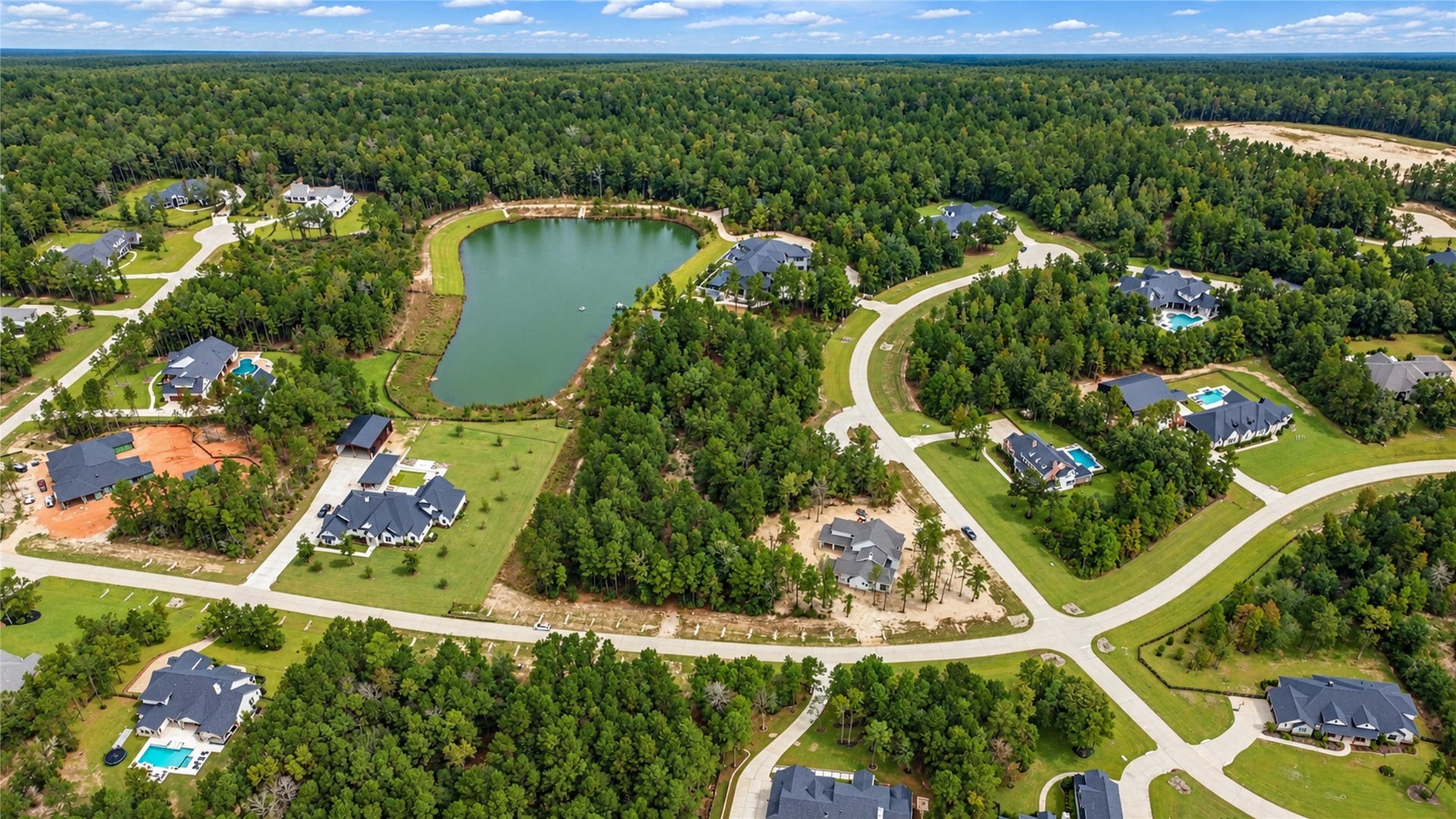 7078 Texas Trace, Montgomery, TX 77316 A broader neighborhood view showcases the nearby lake and surrounding wooded homesites.