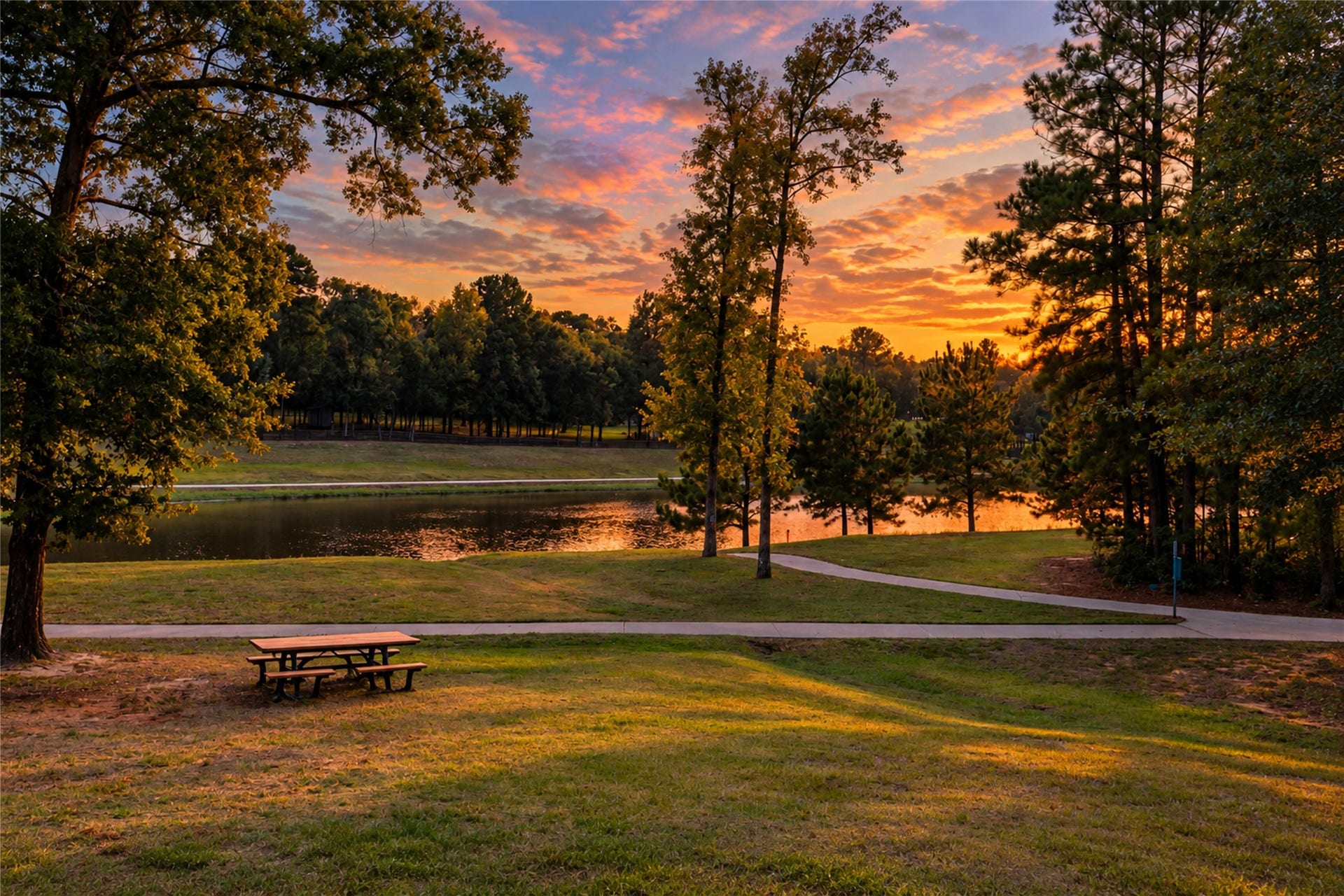7078 Texas Trace, Montgomery, TX 77316 A community lakeside setting with a walking path and picnic table offers a peaceful place to pause.