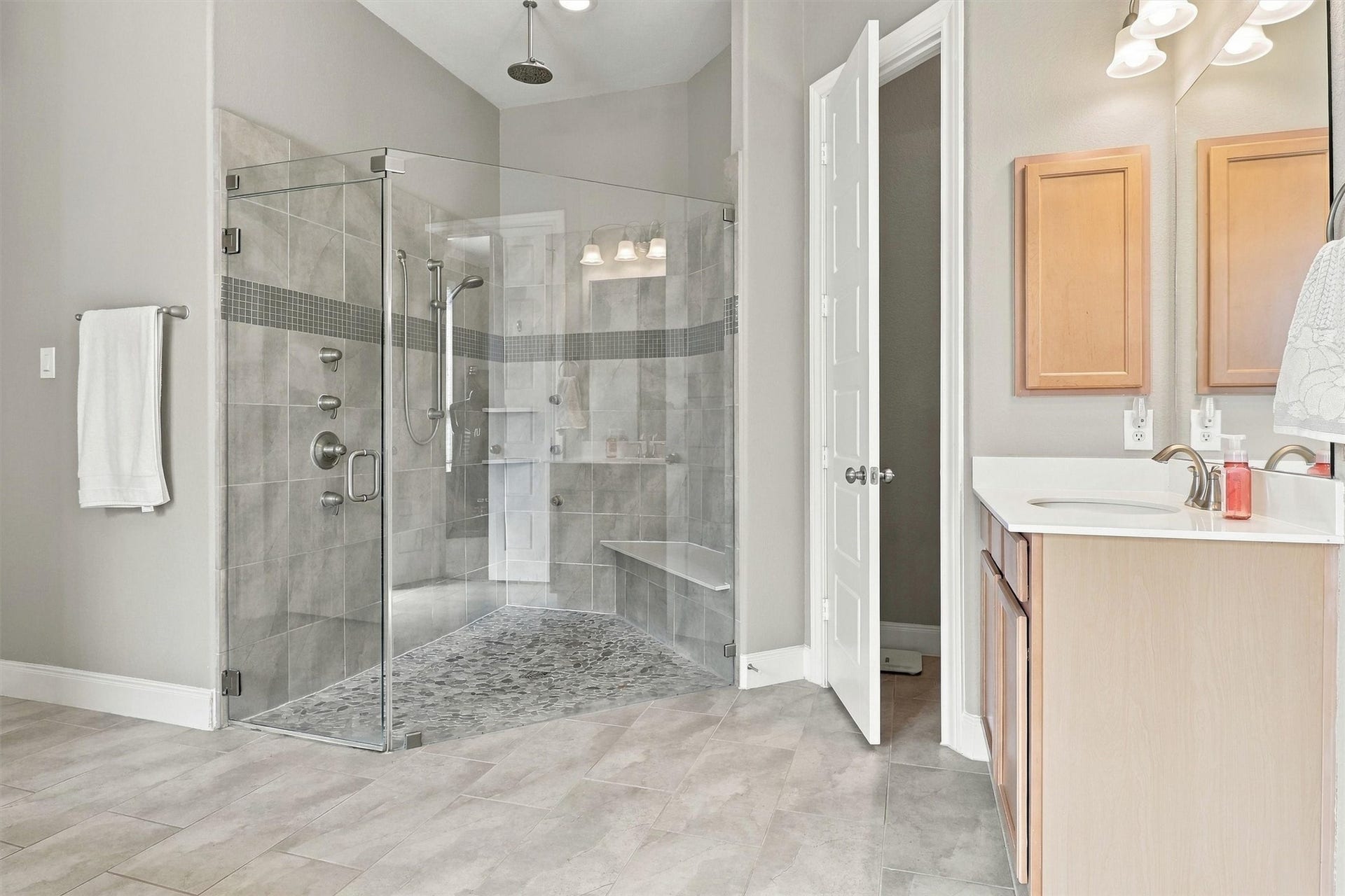 1407 Trails Of Katy Lane, Katy, TX 77494 A shower worth seeing in person. The upgraded primary shower features glass enclosure panels, a tiled seat and multiple shower fixtures, bringing a more indulgent start or finish to your everyday routine.