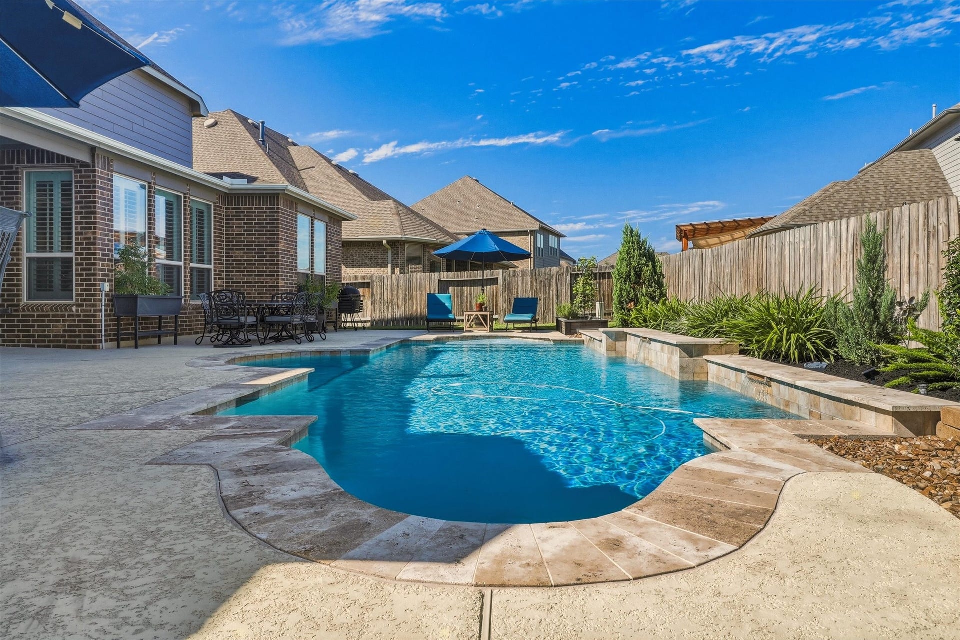 1407 Trails Of Katy Lane, Katy, TX 77494 Step outside and let the day slow down. The pools curved outline, raised feature wall and surrounding deck give the backyard visual interest, with the covered patio nearby when its time for shade or refreshments.