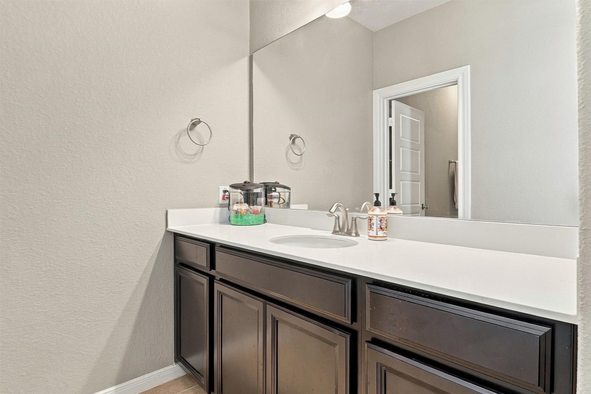 1407 Trails Of Katy Lane, Katy, TX 77494 Everyday comfort, thoughtfully arranged. This upstairs bathroom features a tiled tub-and-shower combination with a recessed niche for bath essentials. A separate vanity area gives guests or household members space to get ready while keeping the bathing area private.