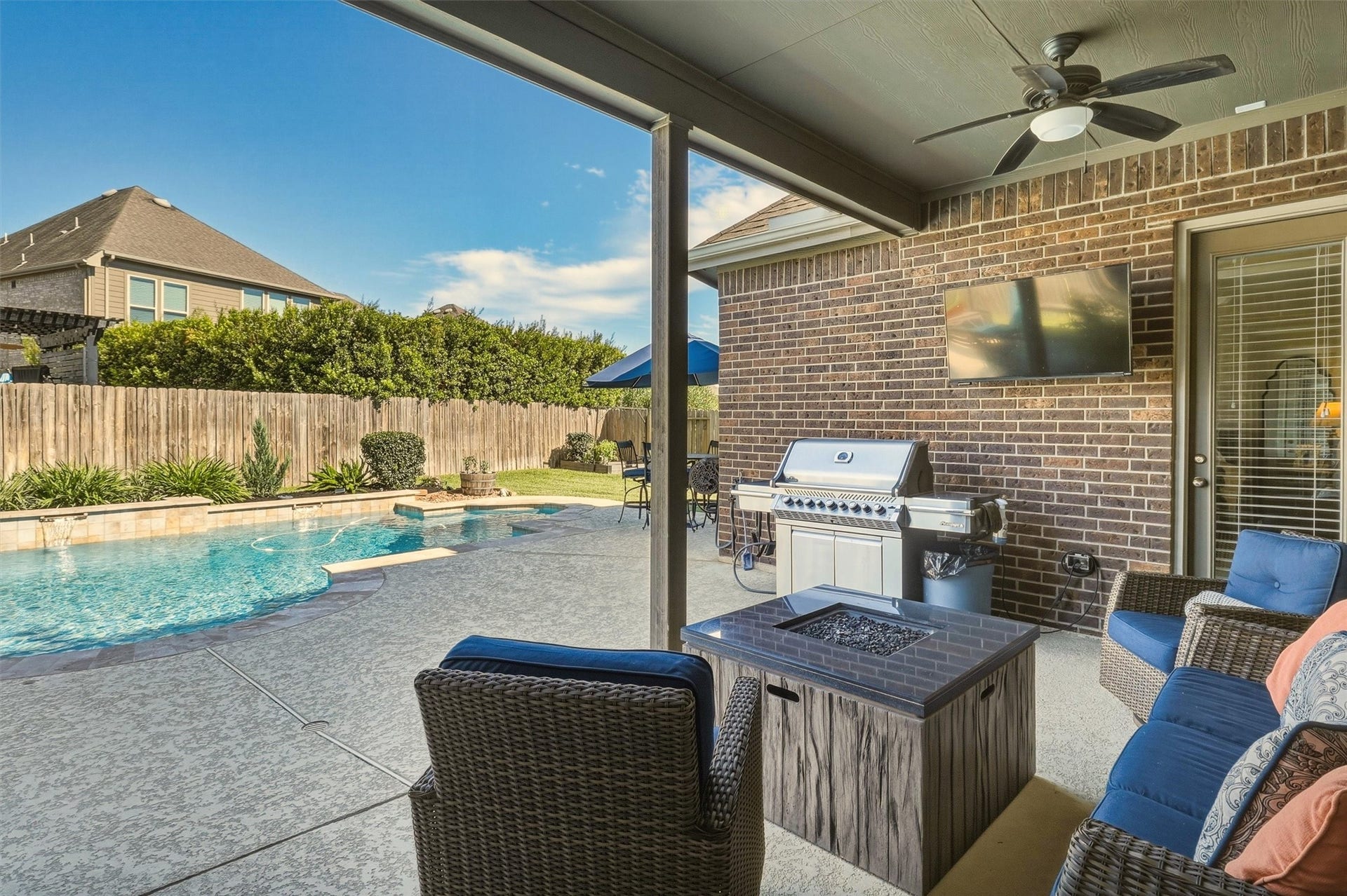 1407 Trails Of Katy Lane, Katy, TX 77494 This is the view that turns lets go out into lets stay here. From the covered patio, the pool is close at hand, letting you enjoy the shade while staying connected to the backyard gathering.
