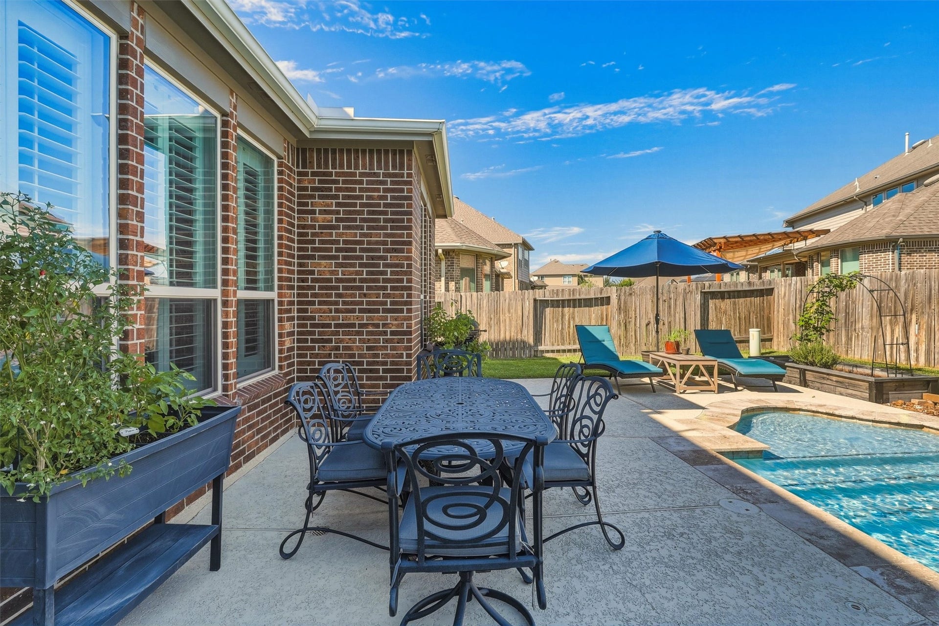 1407 Trails Of Katy Lane, Katy, TX 77494 Lunch by the pool can become an everyday luxury. This angle shows space for outdoor dining beside the water, so a quick swim can turn into a meal outside without leaving the comfort of home.