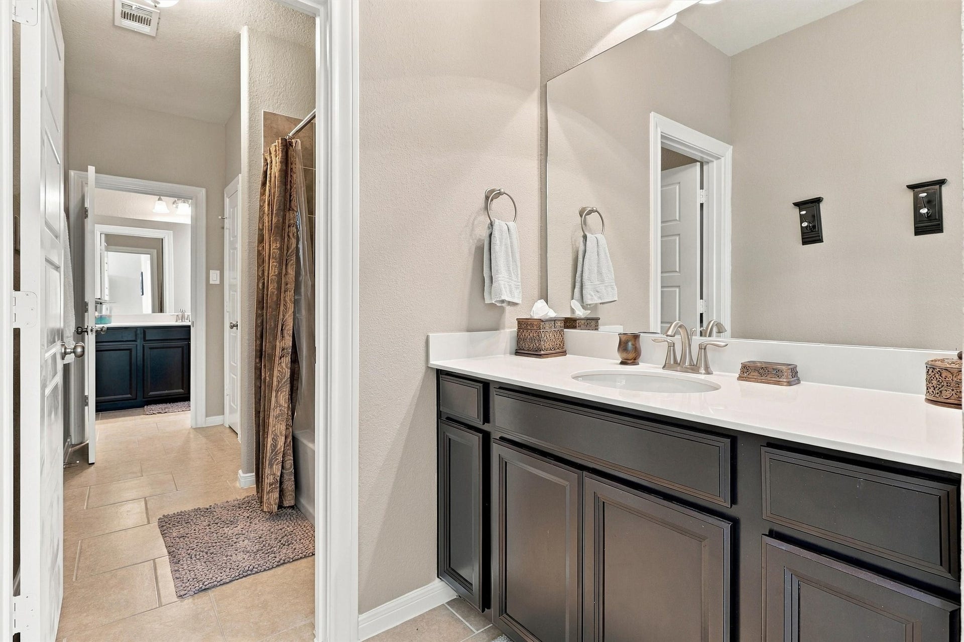 1407 Trails Of Katy Lane, Katy, TX 77494 A broad vanity counter and dark cabinetry bring practical storage to this upstairs bathroom. The bathing area is separately positioned, helping keep getting-ready routines organized when the home is full of people.