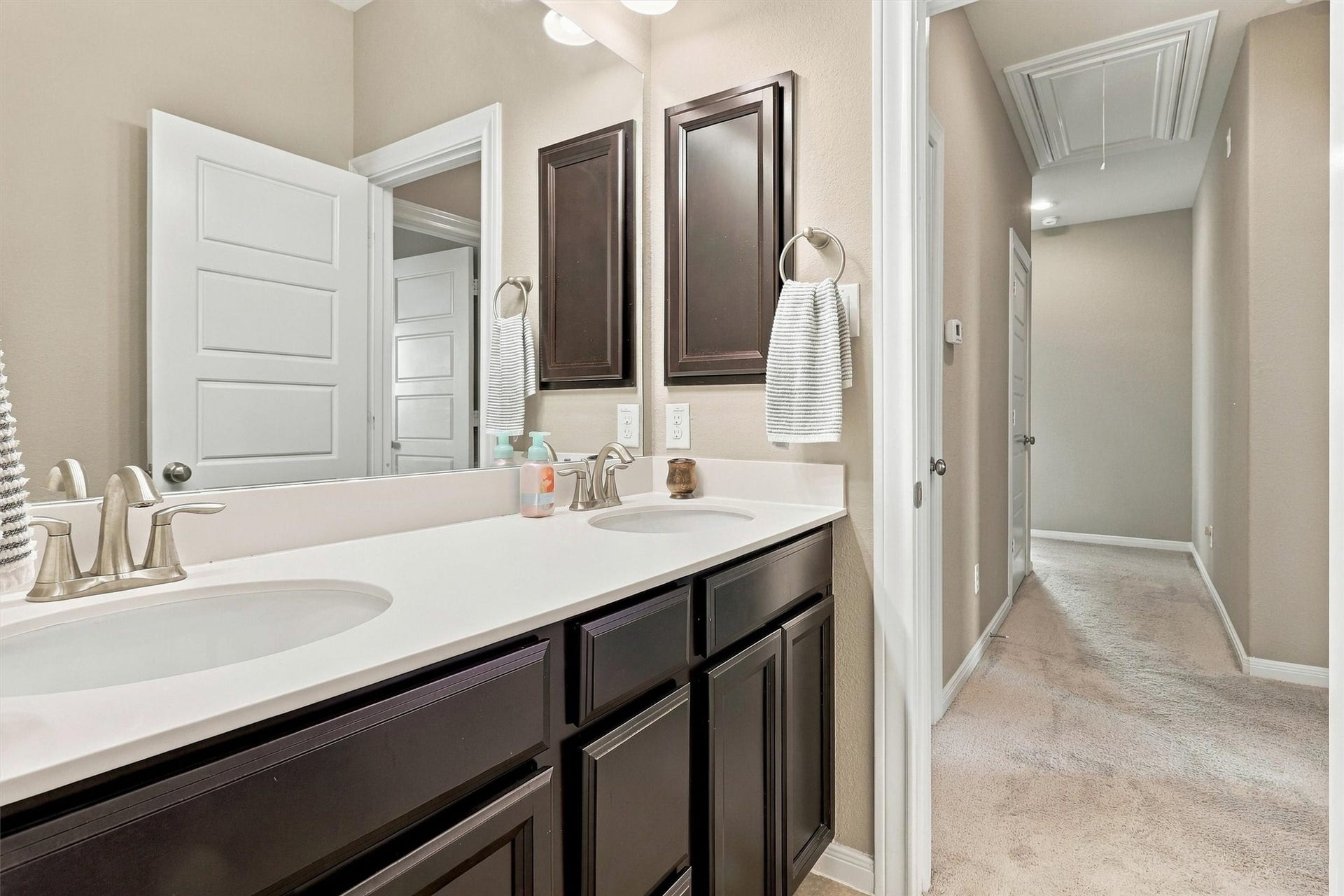 1407 Trails Of Katy Lane, Katy, TX 77494 Another perspective highlights the bathrooms mirror, vanity storage and connection to the bathing area. These everyday details help the upstairs spaces function comfortably when bedrooms are occupied and guests are staying over.