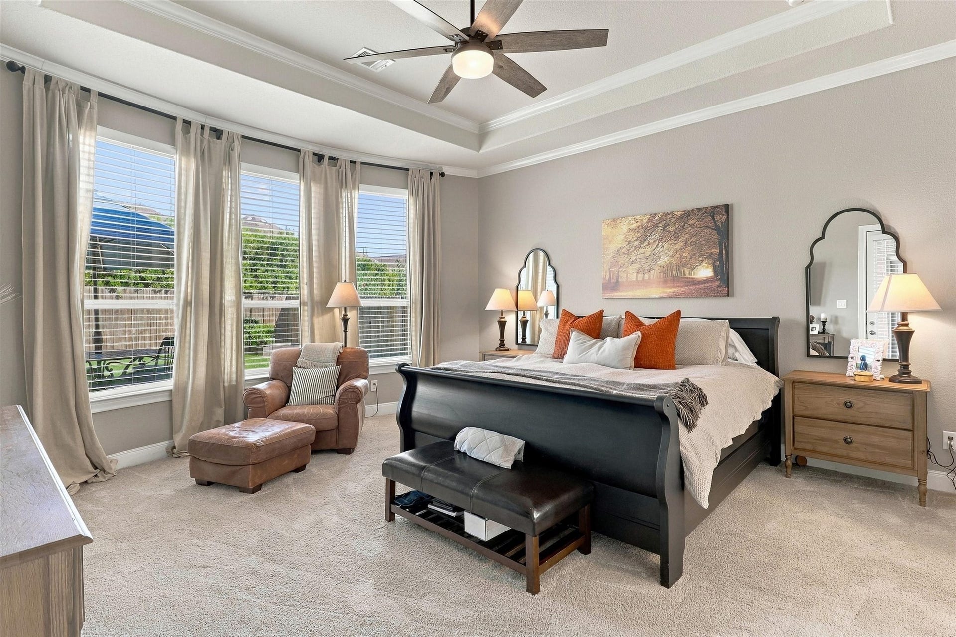 1407 Trails Of Katy Lane, Katy, TX 77494 Let the evening settle around you. The downstairs primary bedroom pairs an upgraded tray ceiling and crown molding with a bay window, creating a spacious retreat with room for a favorite chair and a slower morning.