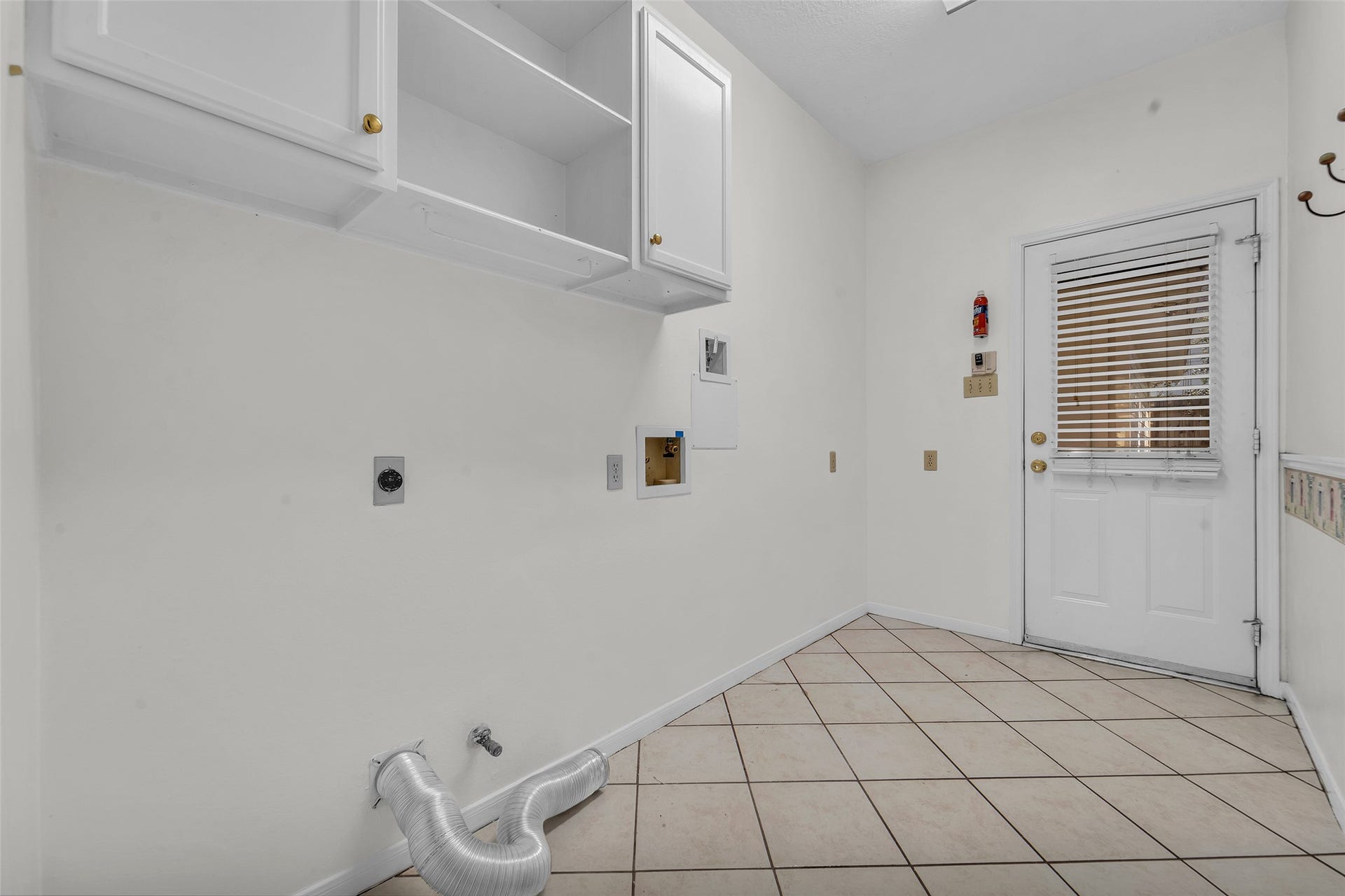 1344 Coleman Boylan Drive, League City, TX 77573 Spacious laundry room with tiled flooring, ample cabinet storage, and convenient outdoor access.