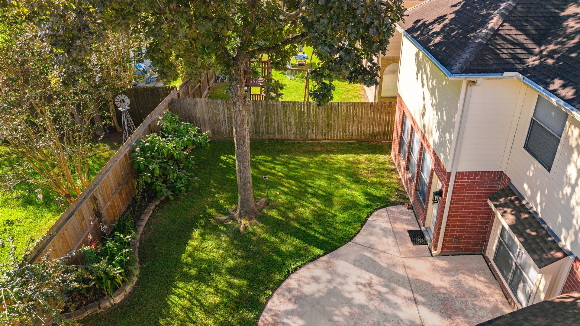 1344 Coleman Boylan Drive, League City, TX 77573 Spacious backyard with a mix of lush greenery and a well-maintained lawn, complemented by a charming patio area perfect for outdoor relaxation.