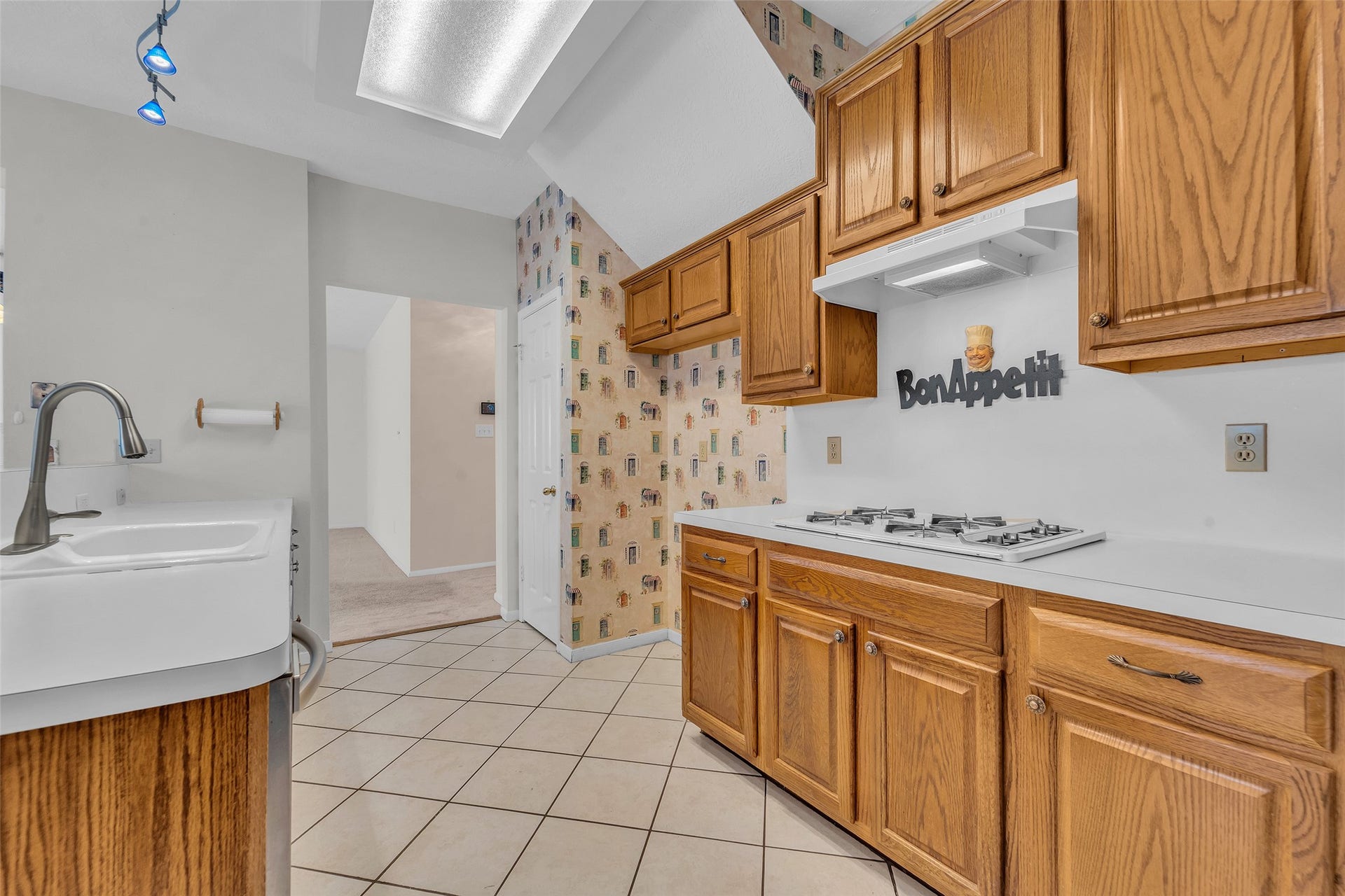 1344 Coleman Boylan Drive, League City, TX 77573 Cozy kitchen with warm wooden cabinetry, a gas cooktop, offering a welcoming atmosphere for culinary adventures.