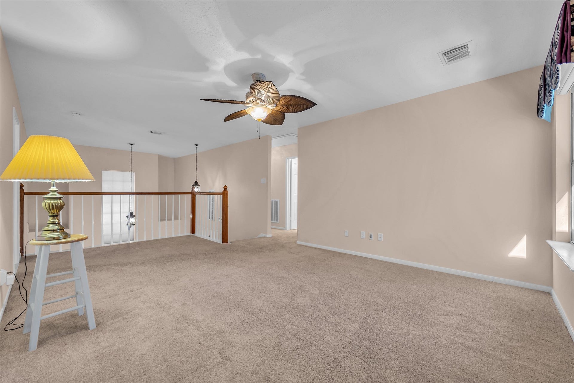 1344 Coleman Boylan Drive, League City, TX 77573 Spacious upstairs area with soft carpet, neutral walls, and a stylish ceiling fan, offering a cozy and versatile living space.