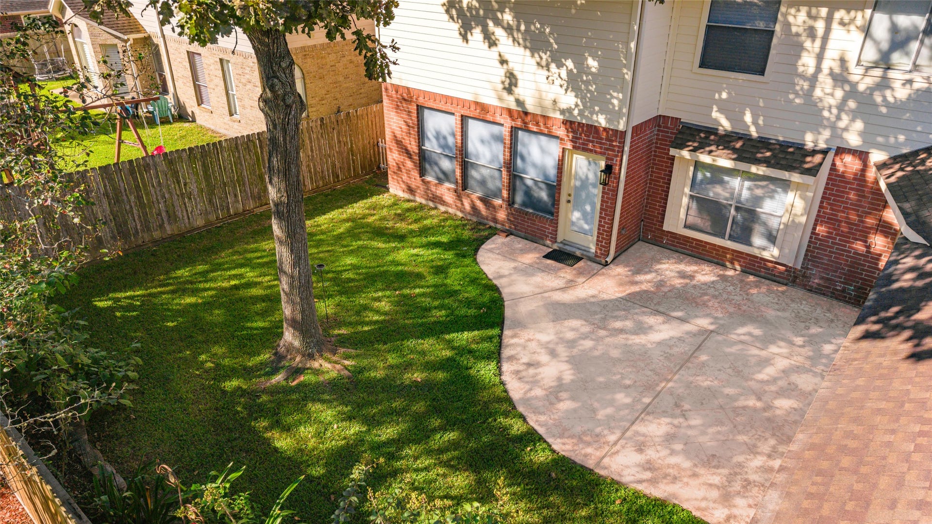 1344 Coleman Boylan Drive, League City, TX 77573 Charming backyard with a spacious patio perfect for entertaining, surrounded by lush greenery and a beautiful mature tree.