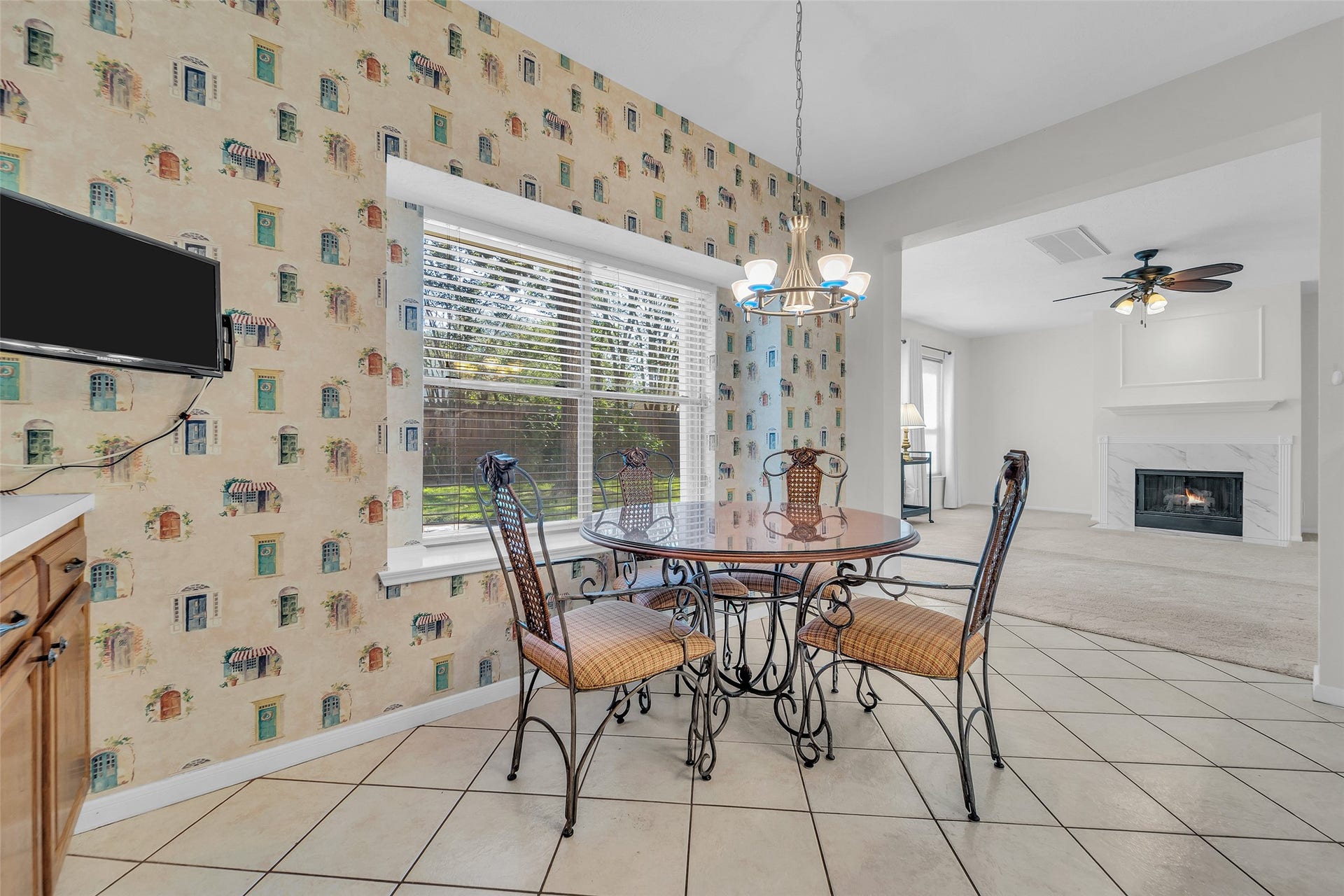 1344 Coleman Boylan Drive, League City, TX 77573 Charming dining area with natural light, adjacent to a cozy living room featuring a fireplace and ceiling fan.