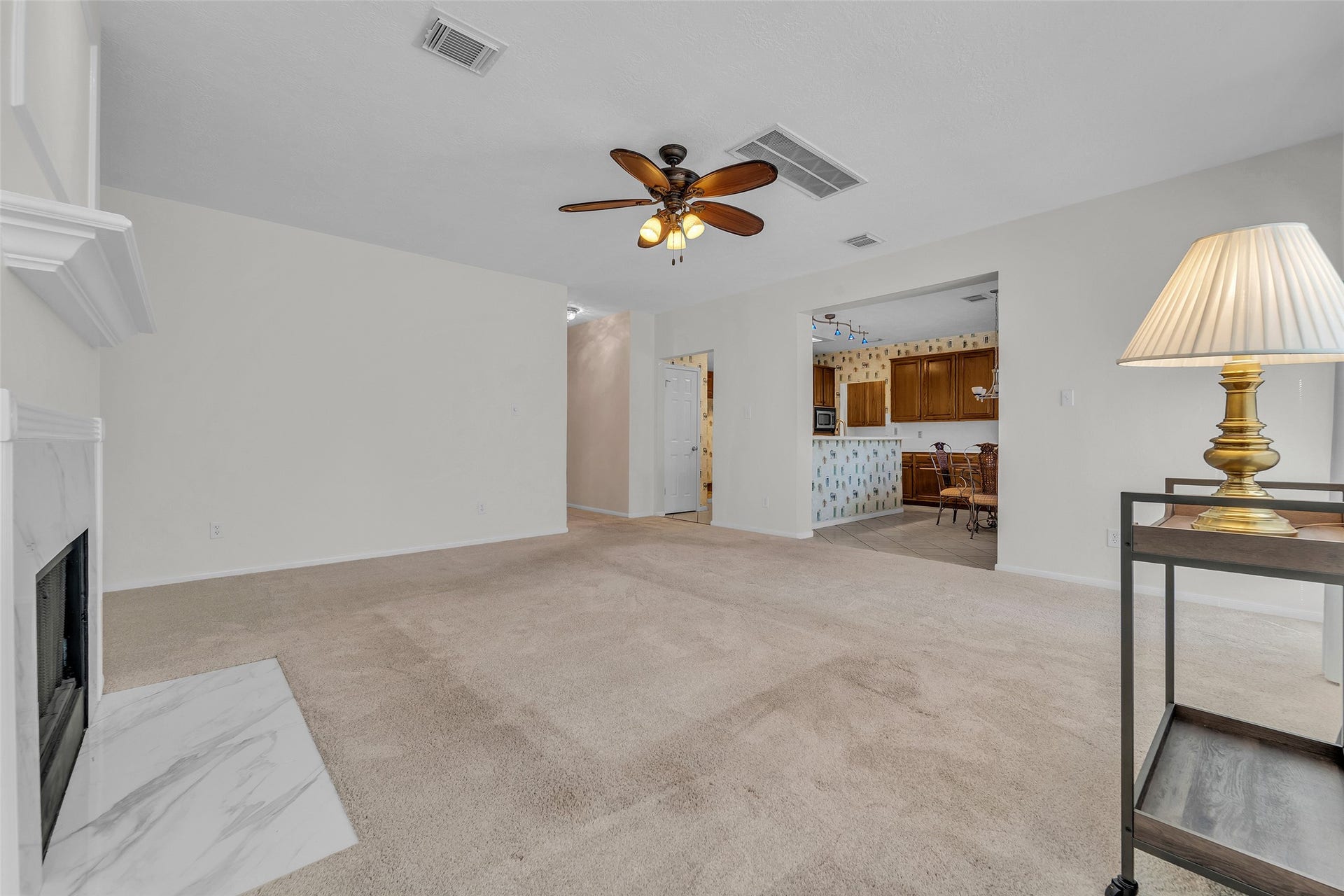1344 Coleman Boylan Drive, League City, TX 77573 Spacious living area with a cozy fireplace, neutral carpeting, and direct access to the kitchen, perfect for entertaining.