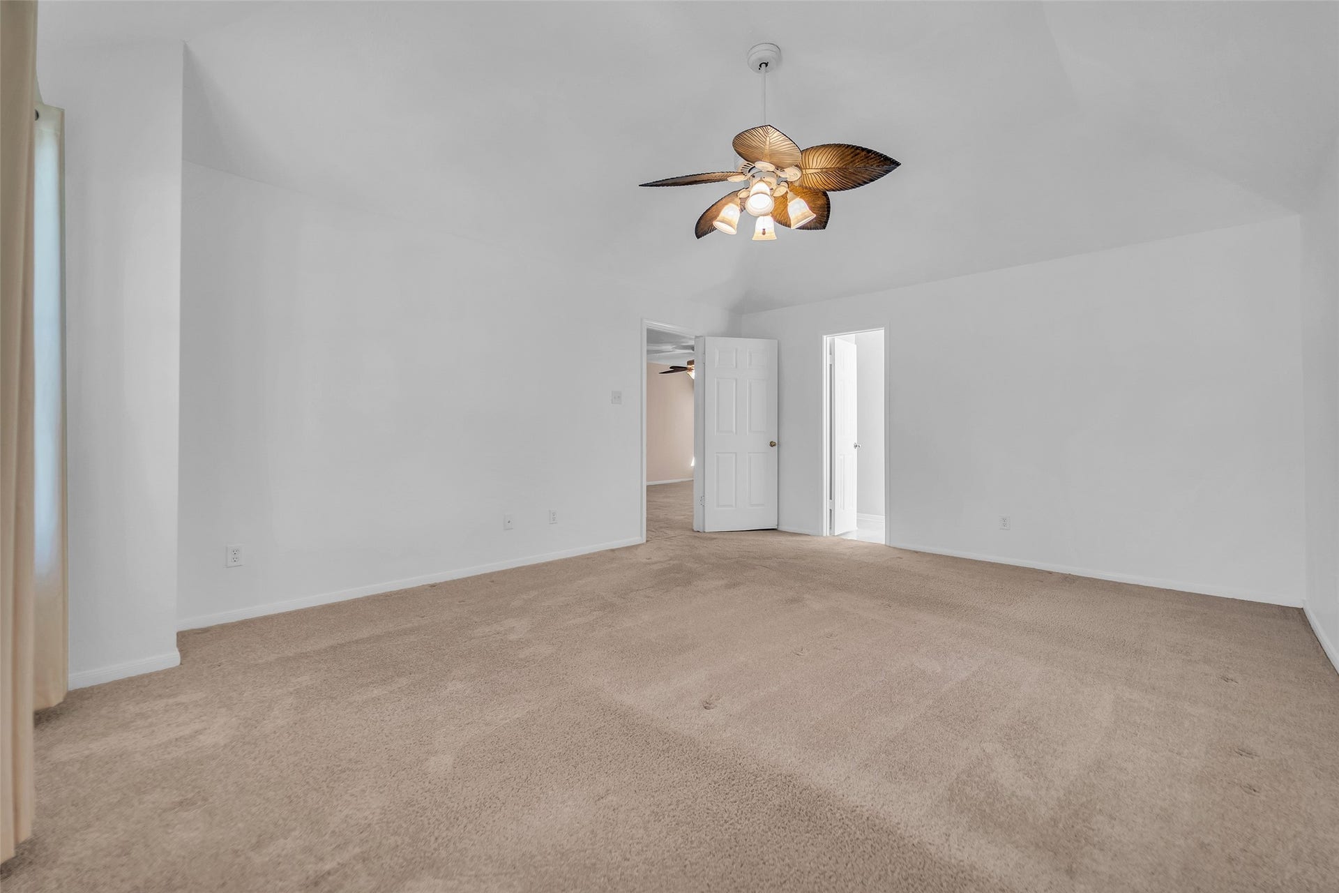 1344 Coleman Boylan Drive, League City, TX 77573 Spacious bedroom with a vaulted ceiling, featuring a unique ceiling fan and neutral-toned carpet, offering ample natural light and a cozy atmosphere.