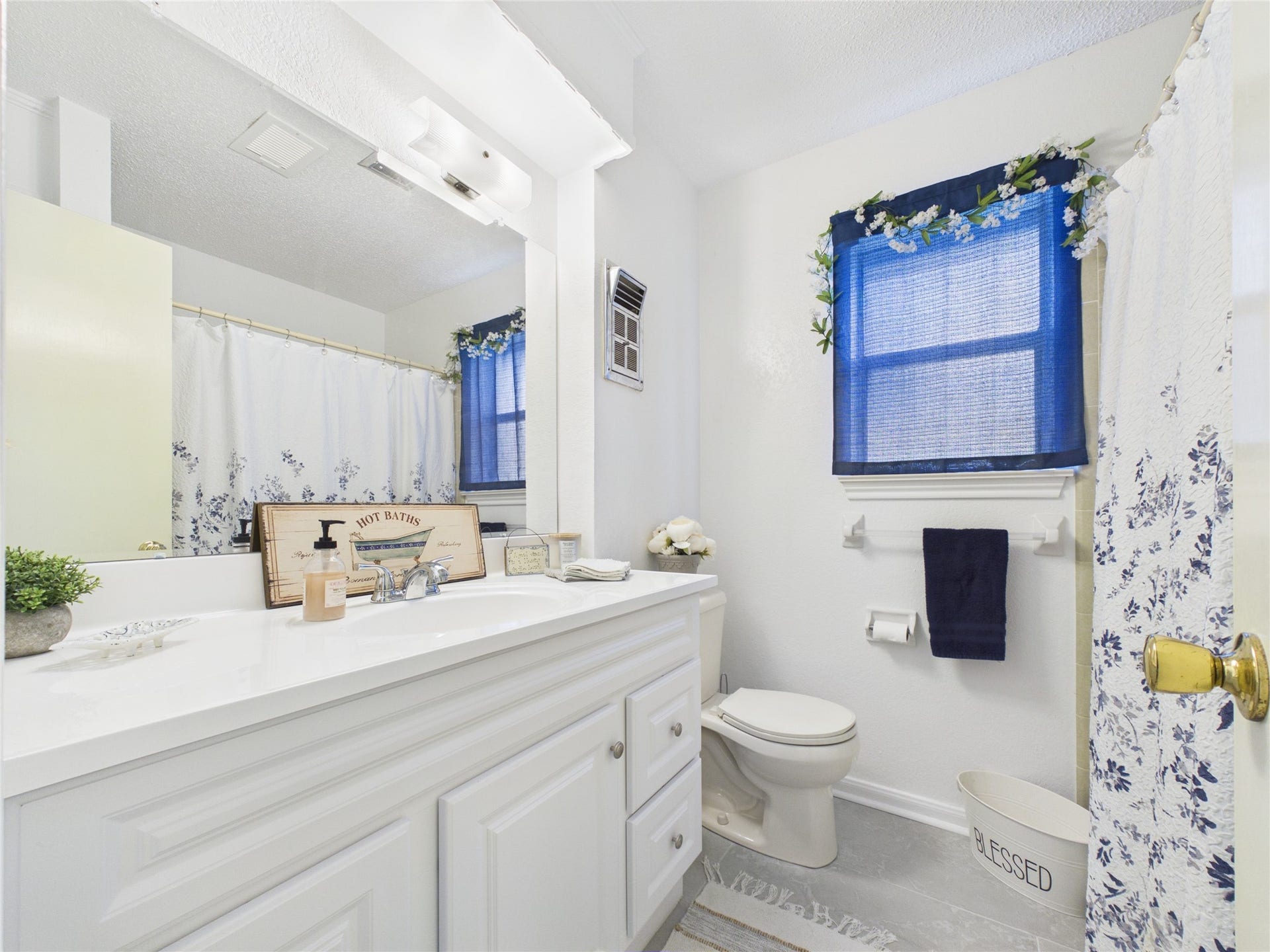 1909 Tracy Lynn Lane, Alvin, TX 77511 Secondary bathroom with recent updates: vanity, tile floors, plumbing fixtures. There's also a linen closet behind the door offering plenty of storage for linens, towels, supplies.