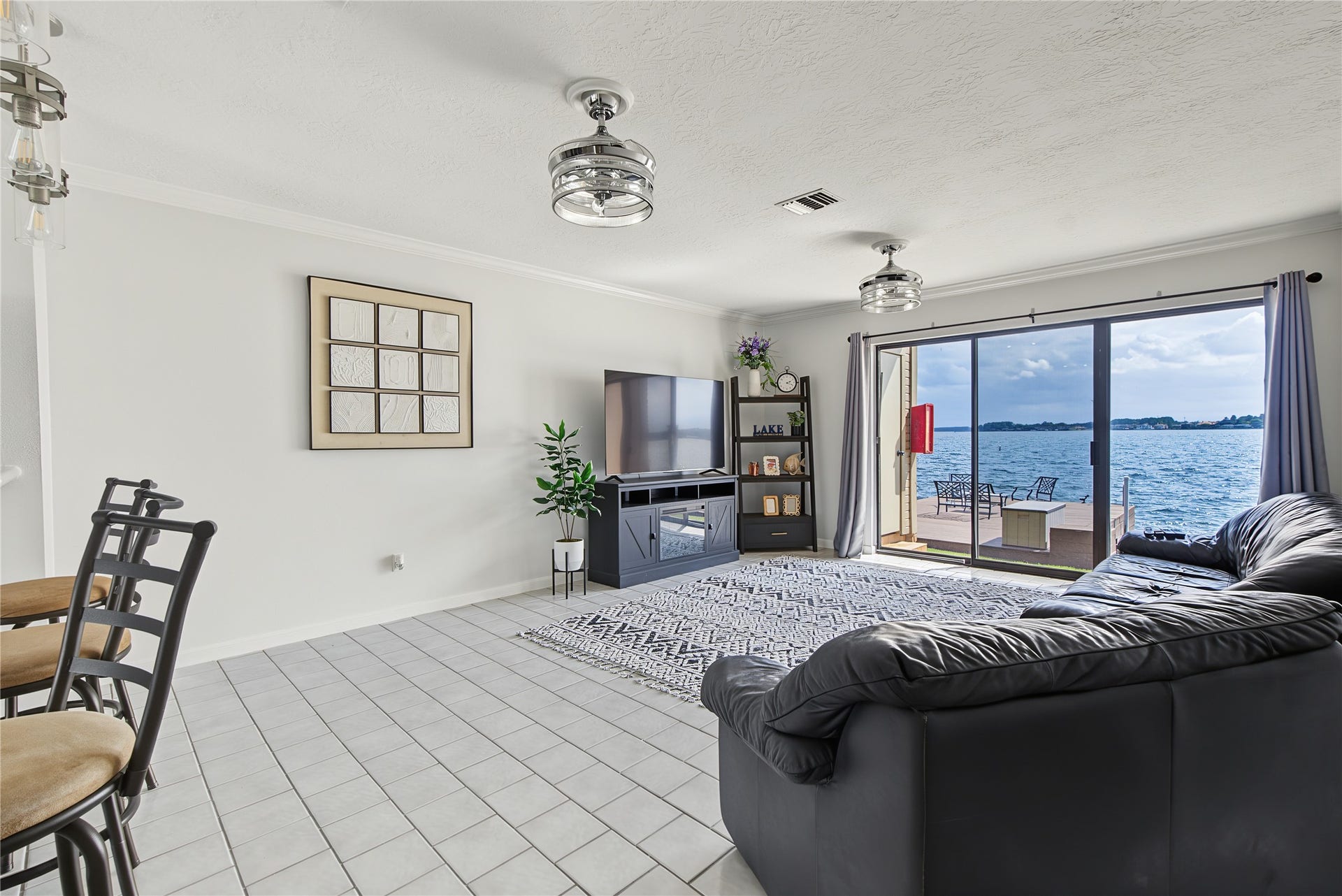 Open-concept living area with tile flooring and sliding glass doors framing the beautiful lake views.