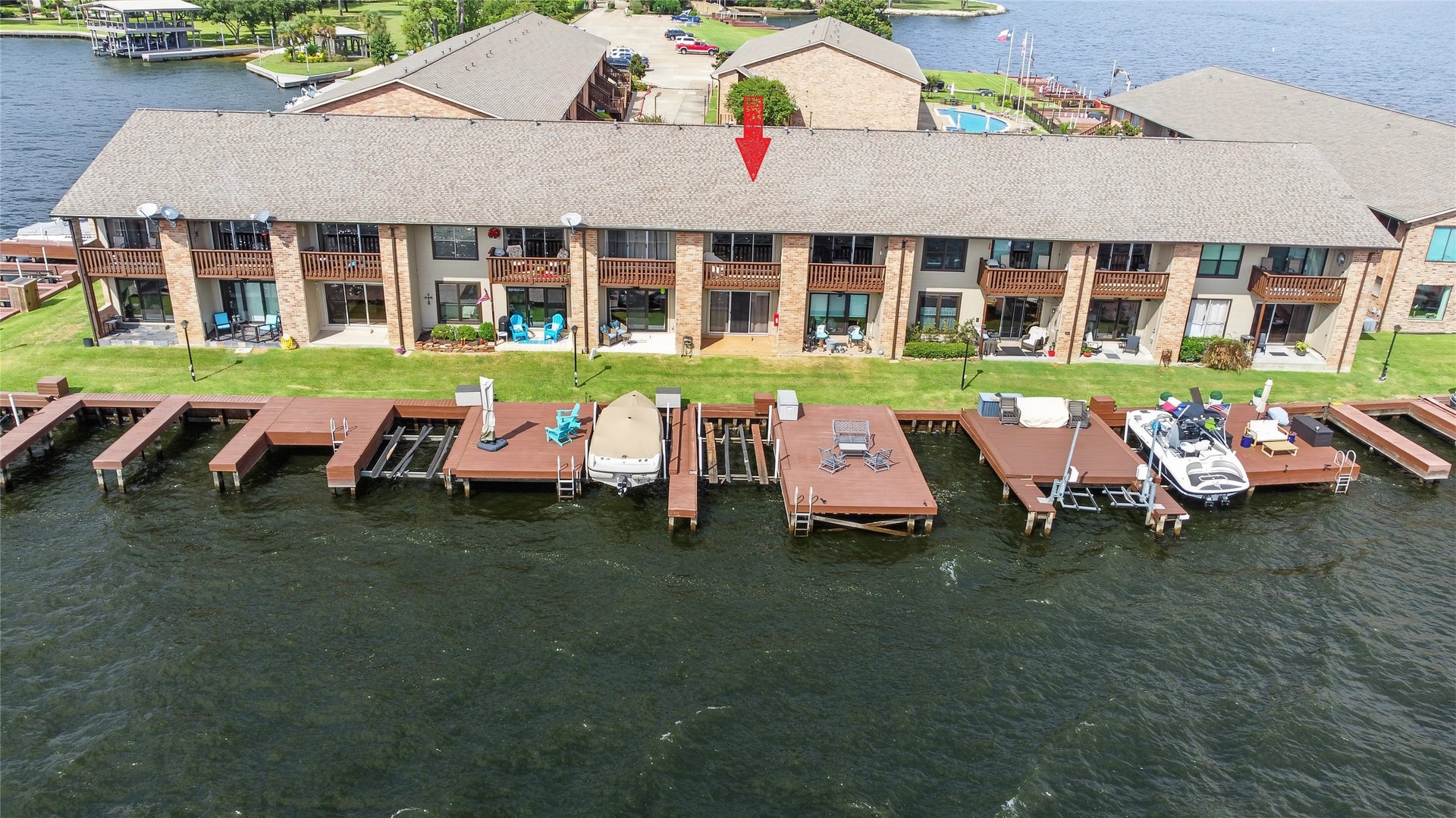 Elevated view capturing the waterfront buildings, marina-style boat slips, and scenic shoreline.