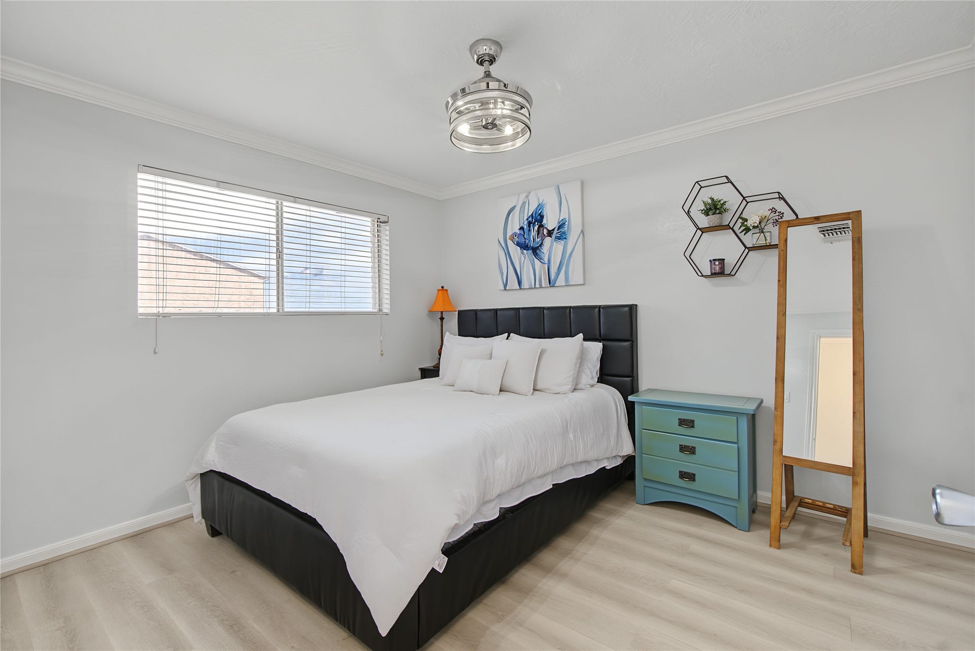 Comfortable primary bedroom with natural light, wood-look flooring, and ceiling fan.