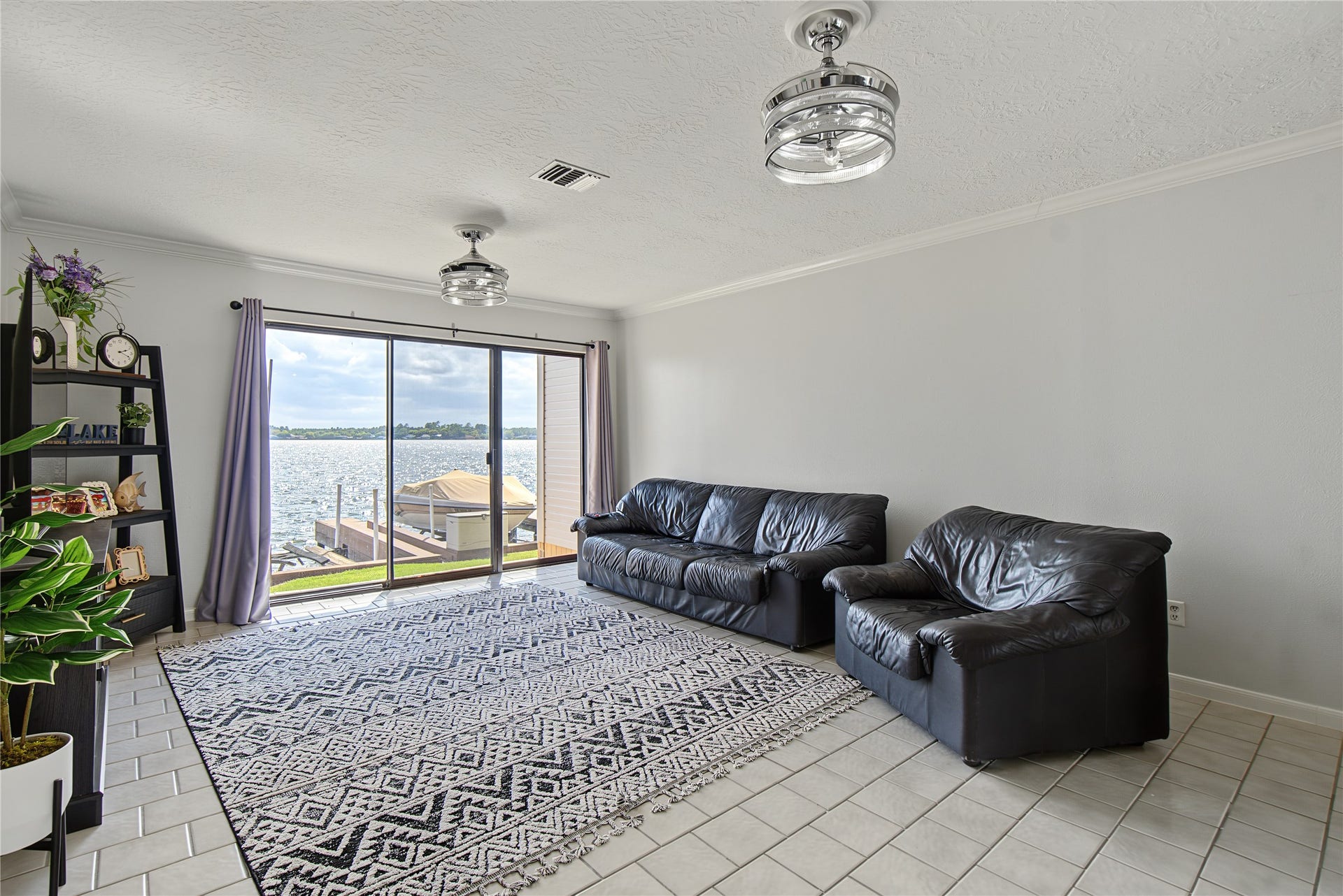 Relax in the living room while enjoying unobstructed views of Lake Conroe through the sliding glass doors.
