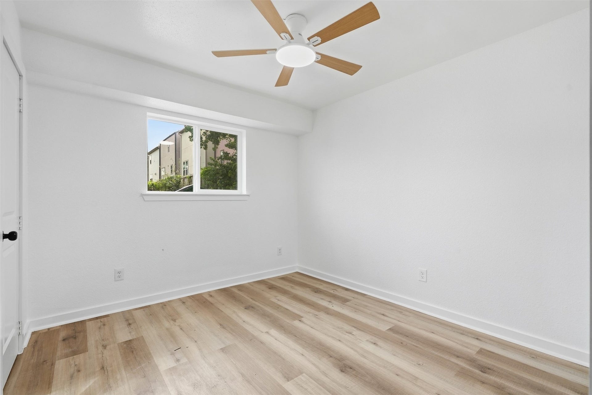 1936 Upland Drive, Houston, TX 77043 Bright and airy bedroom featuring fresh white walls, a modern ceiling fan, and elegant wood flooring, ideal for creating a peaceful retreat.