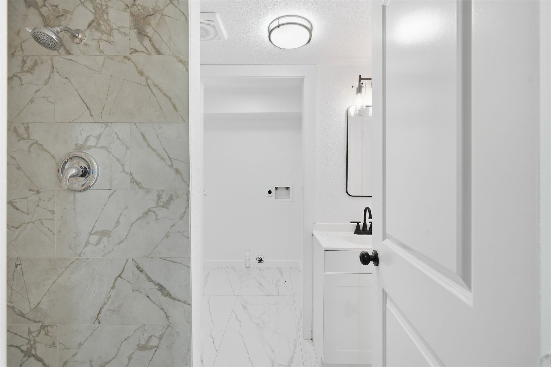 1936 Upland Drive, Houston, TX 77043 Experience modern elegance in this bathroom, featuring sleek marble tile in the shower and a contemporary vanity with stylish fixtures.