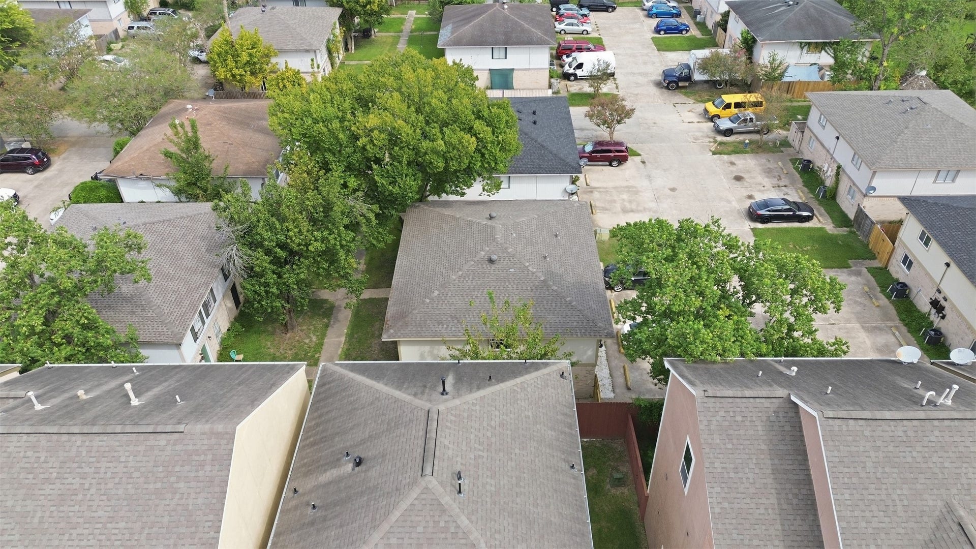 1936 Upland Drive, Houston, TX 77043 Aerial view of a residential neighborhood showcasing a series of homes with ample parking space and mature trees, providing a sense of community and greenery.