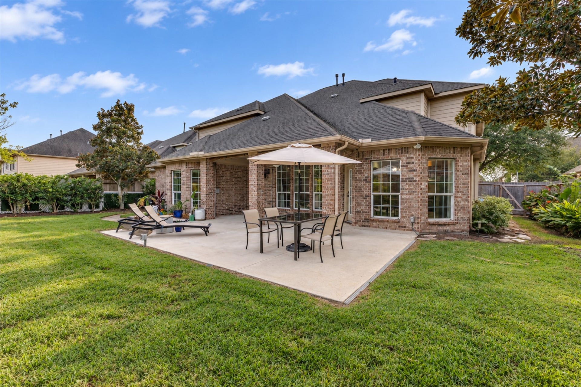 An expansive patio and manicured lawn create a wonderful setting for gatherings and outdoor activities.