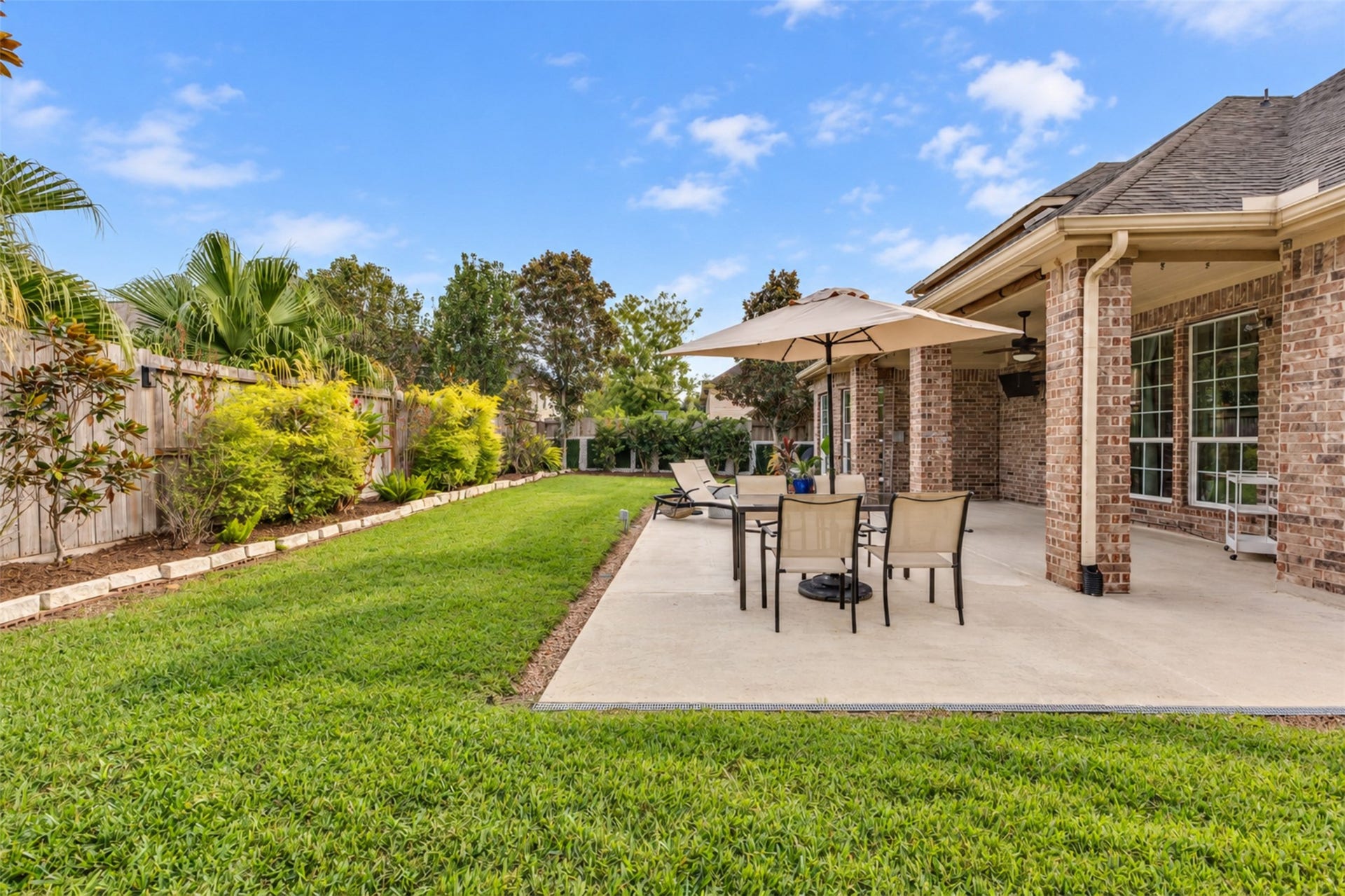 Spacious patio with room for outdoor dining, lounging, and enjoying the backyard.