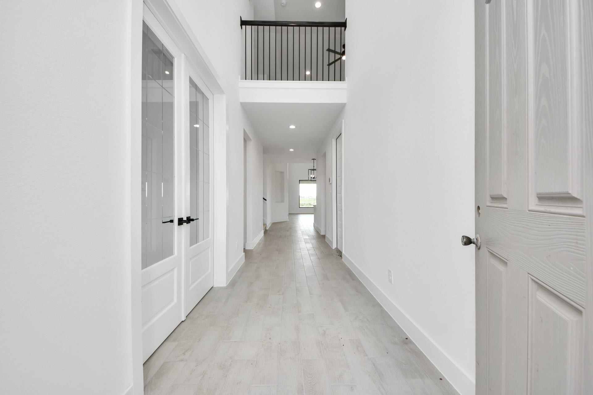 5914 Fox Peak Lane, Richmond, TX 77469 As you step into the threshold of this luxurious home, you'll soon be welcomed by an elegant glass door (to be installed). Inside, soaring ceilings amplify the spaciousness, while the refined wood-look tile flooring and oversized baseboards exude sophistication and charm. Sample photo of completed home with similar floor plan. Actual colors and selections may vary.