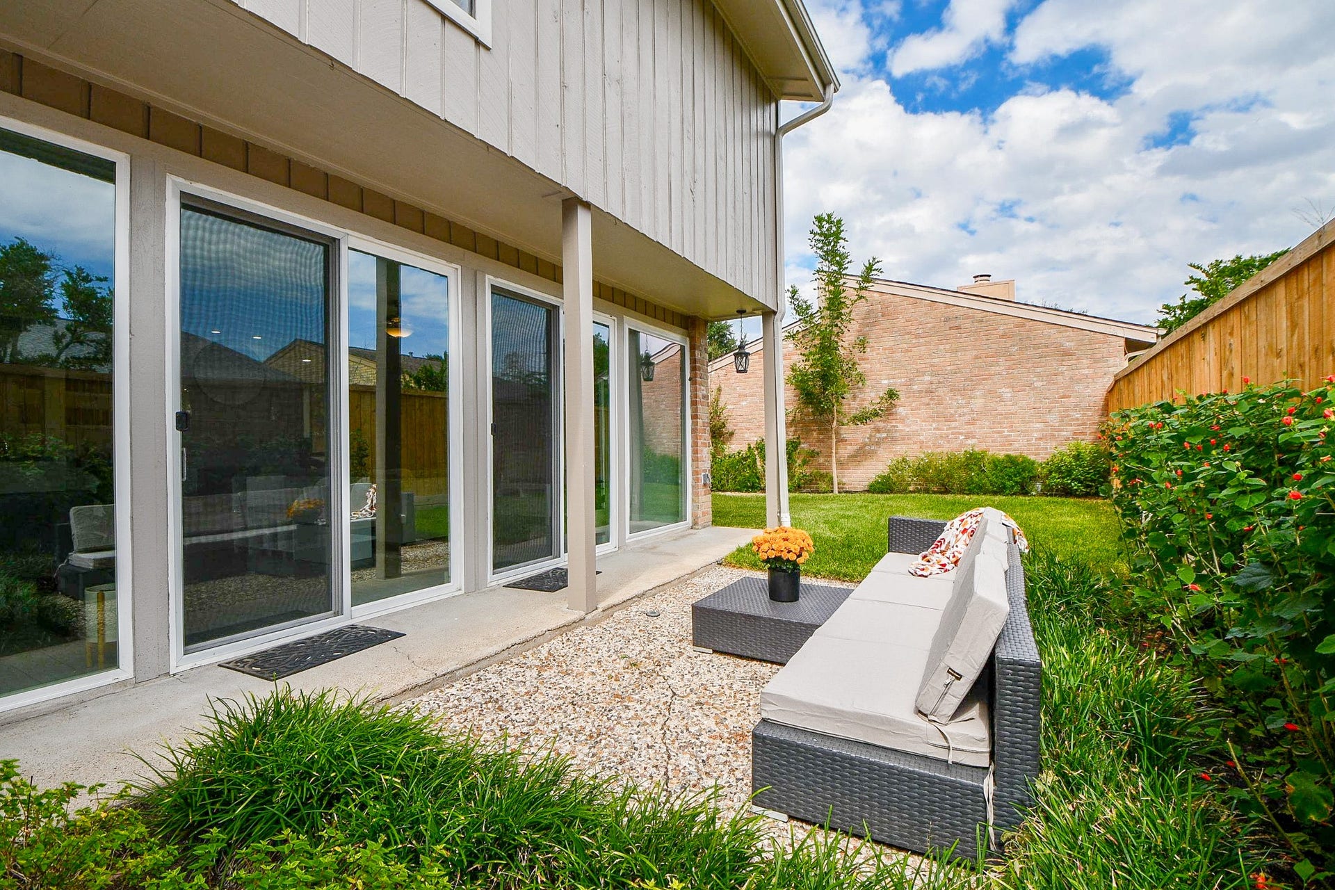 811 Bayou River Drive, Houston, TX 77079 Floor-to-ceiling sliding doors open from the living area to the covered patio and backyard.