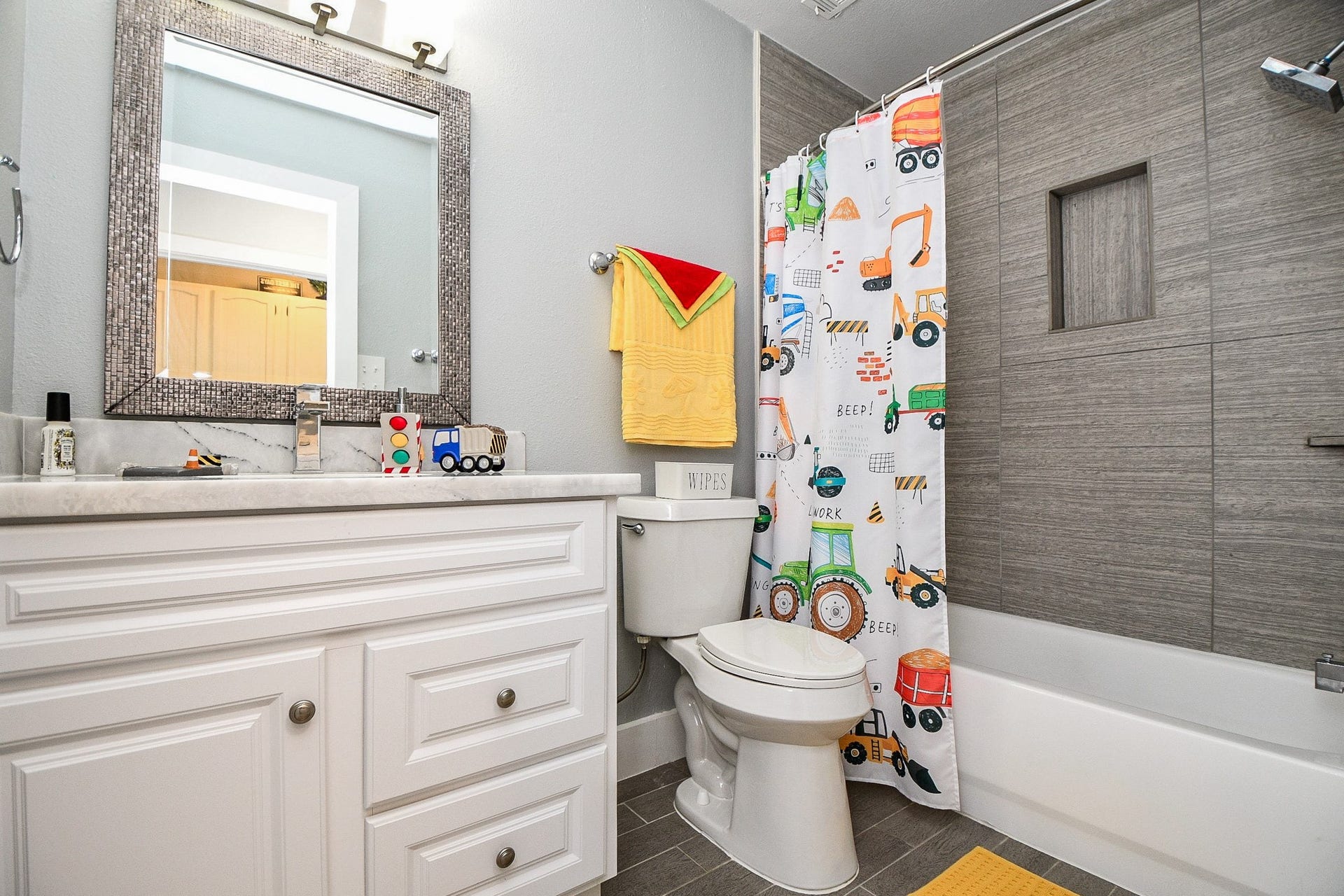 811 Bayou River Drive, Houston, TX 77079 The secondary bath has a white vanity and a tub/shower combo with a modern tile surround and built-in niche.