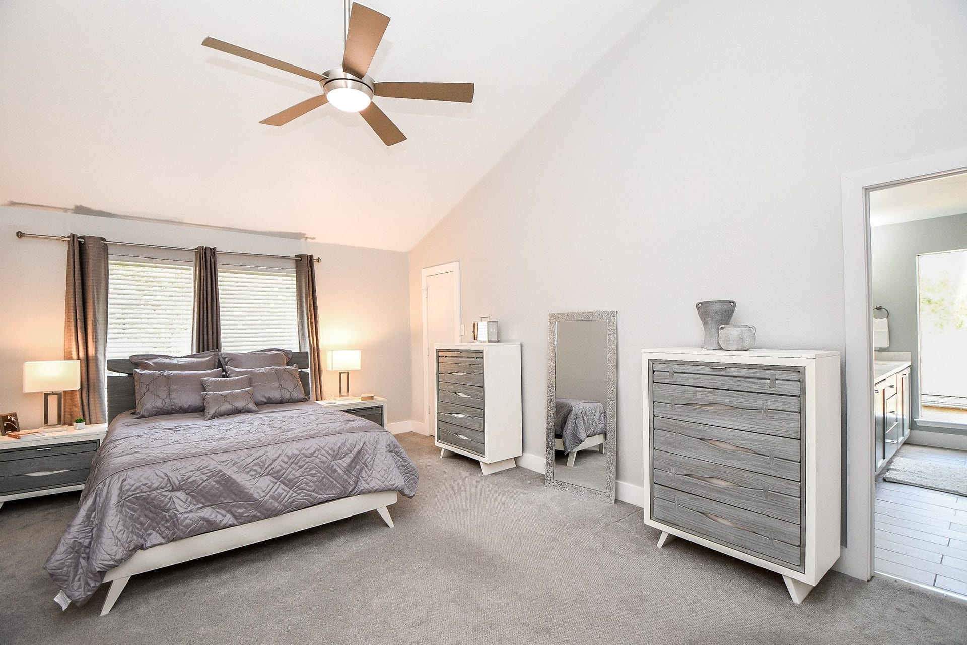 811 Bayou River Drive, Houston, TX 77079 The spacious primary bedroom has vaulted ceilings, a ceiling fan, and plush carpet.